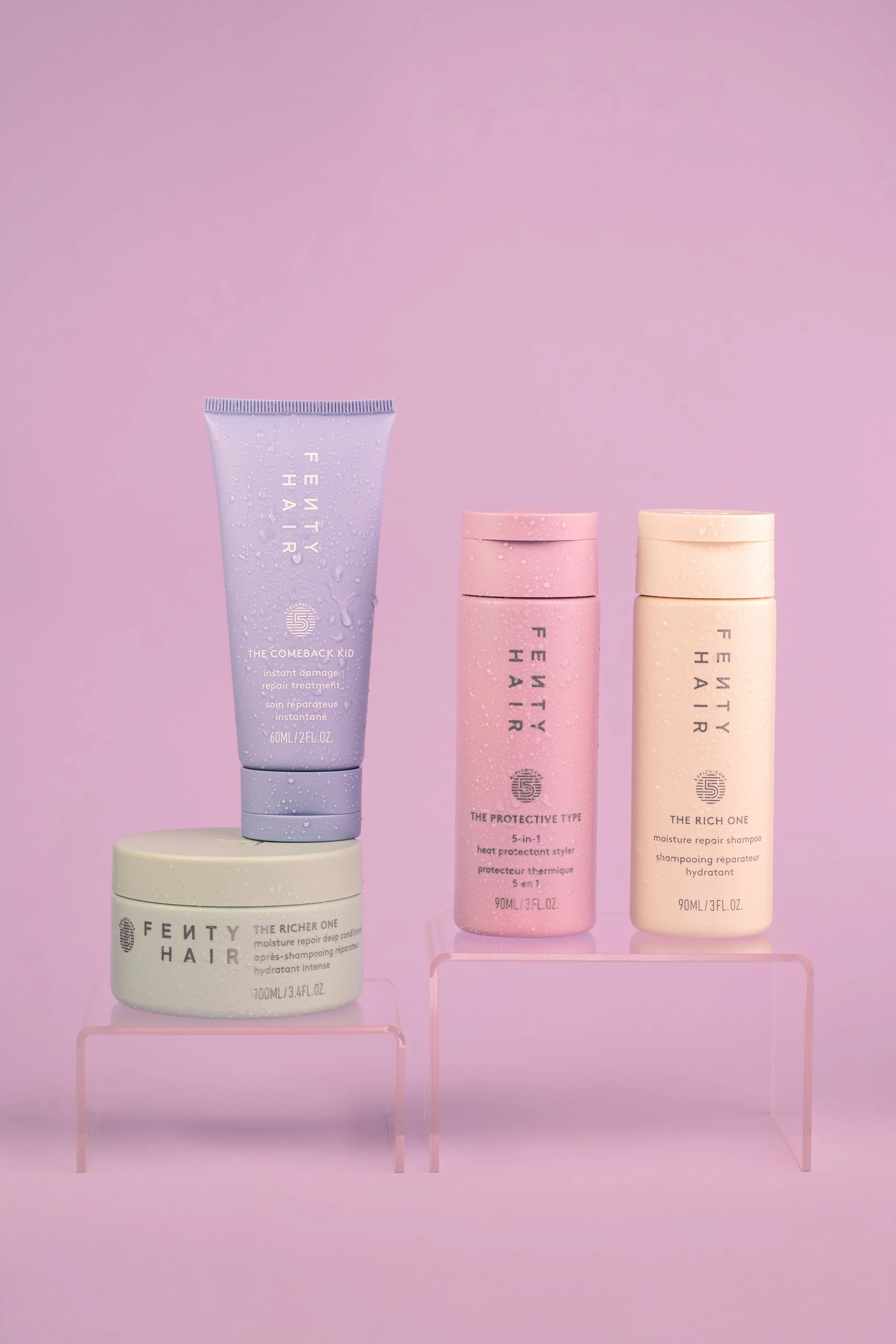 Fenty Hair products styled on a soft pink background with water droplets and pastel tones.
