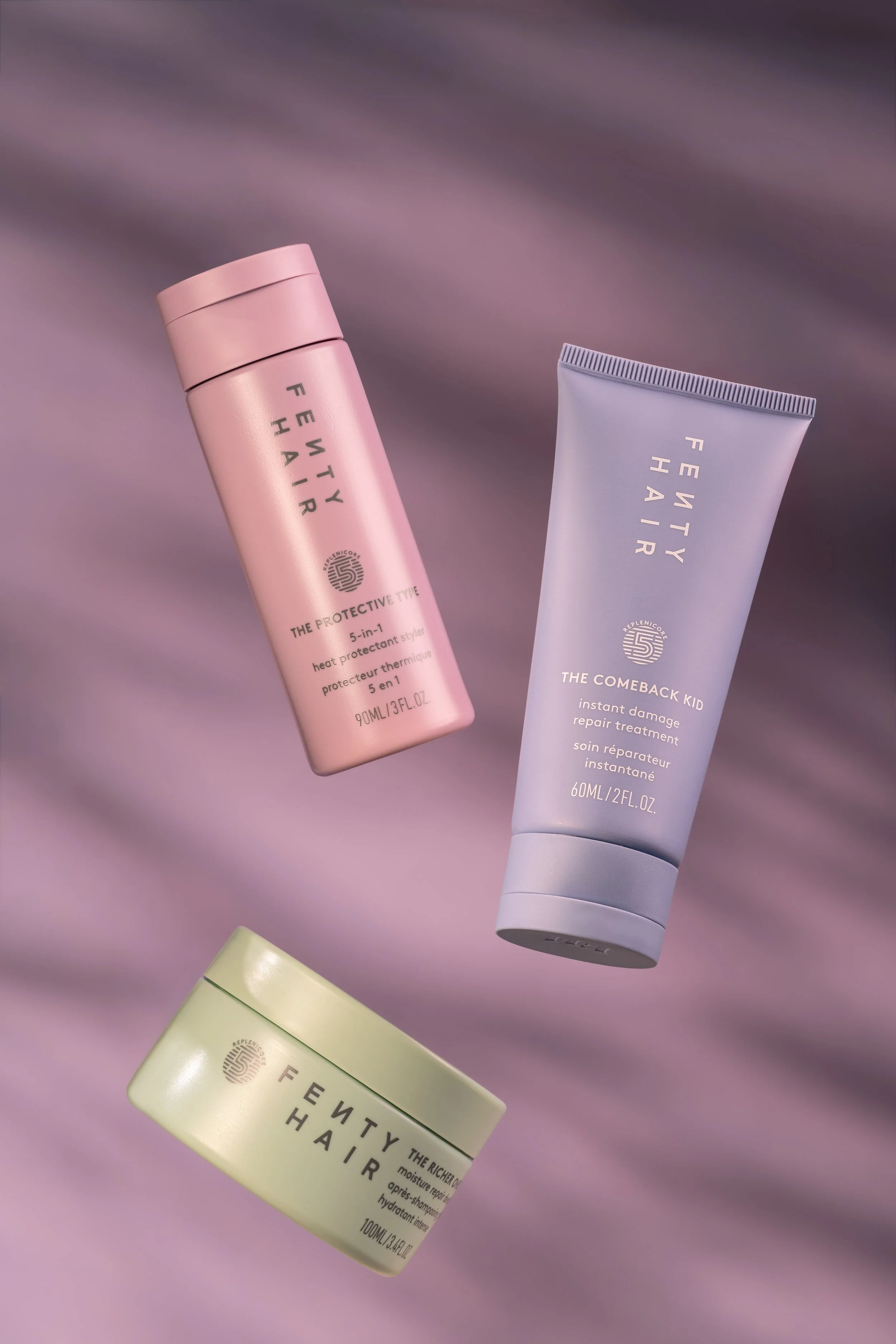 Pastel-colored beauty products arranged on a soft lavender surface in a clean editorial flat lay composition.