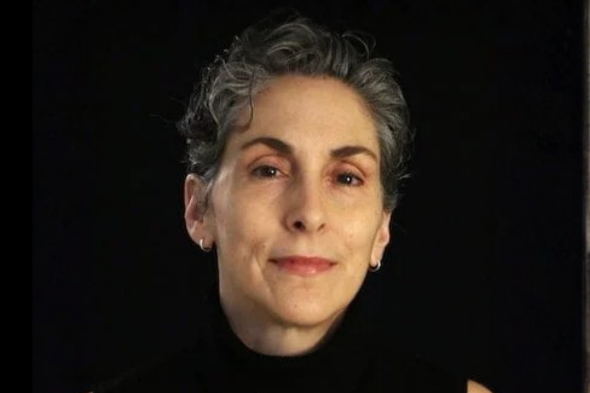 A woman with a black shirt in front of a black background