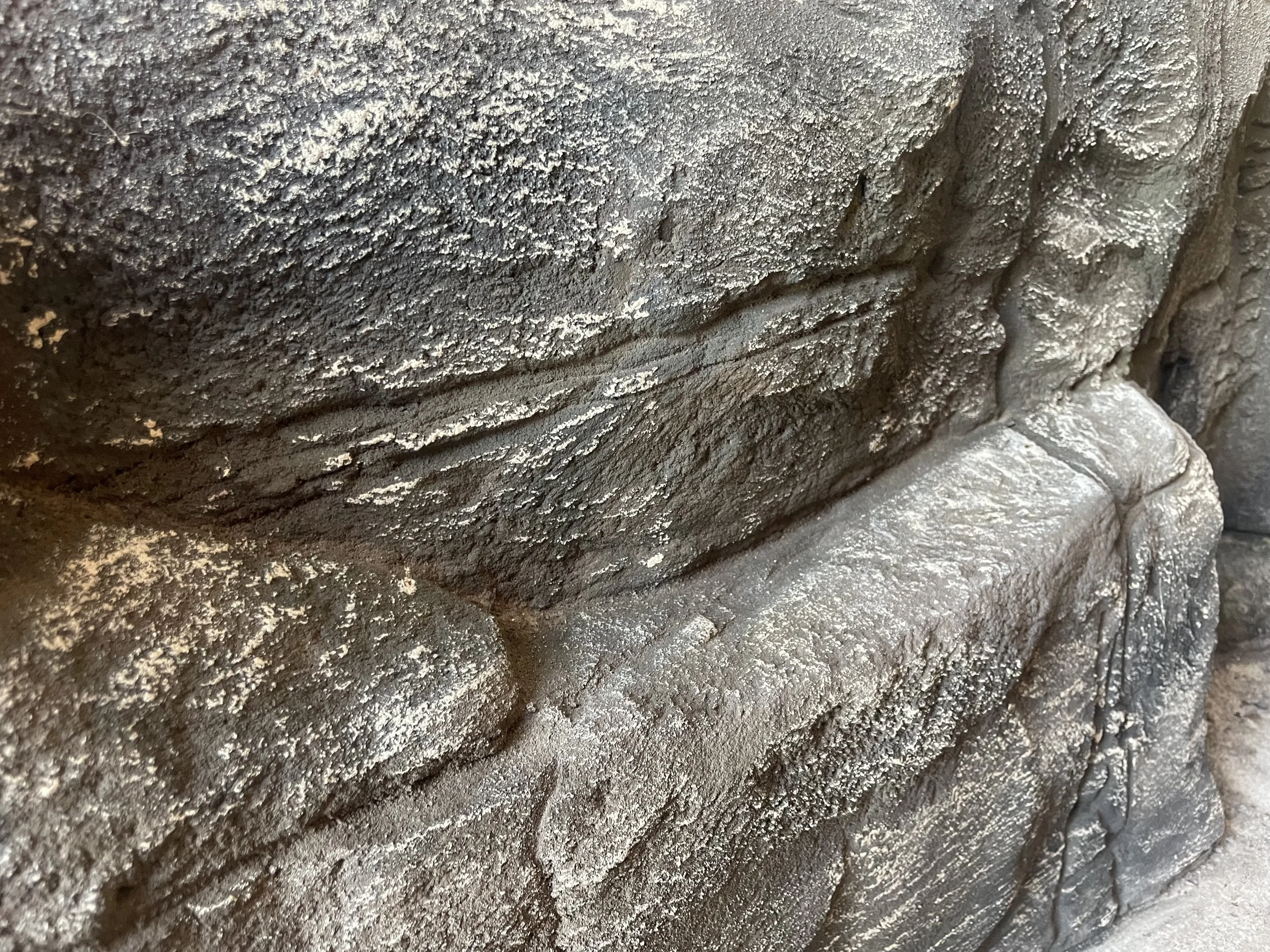 Close-up of a textured stone wall made of bricks with a rough surface.
