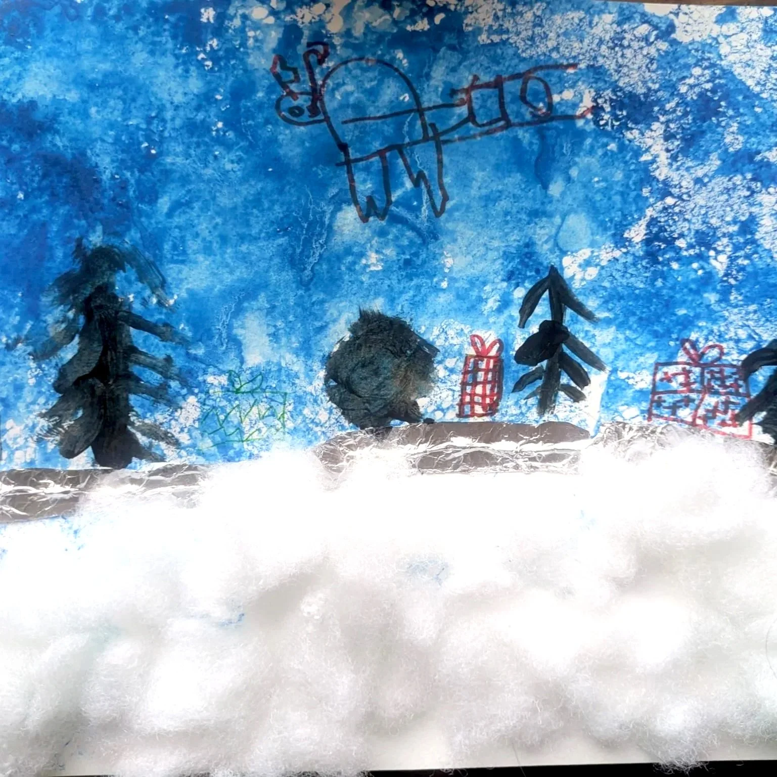 Children's winter craft with drawings of pine trees, gifts, and a reindeer in a snowy landscape.