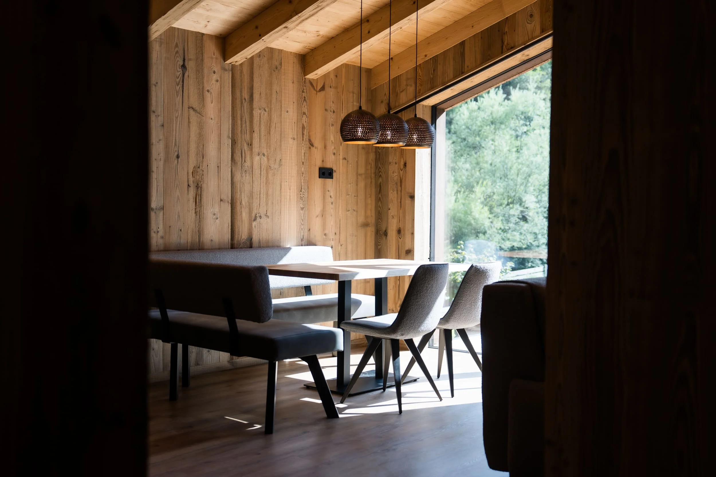 Heller Wohn- und Essbereich im SLØW Chalet mit moderner Einrichtung und großflächigen Fenstern.
