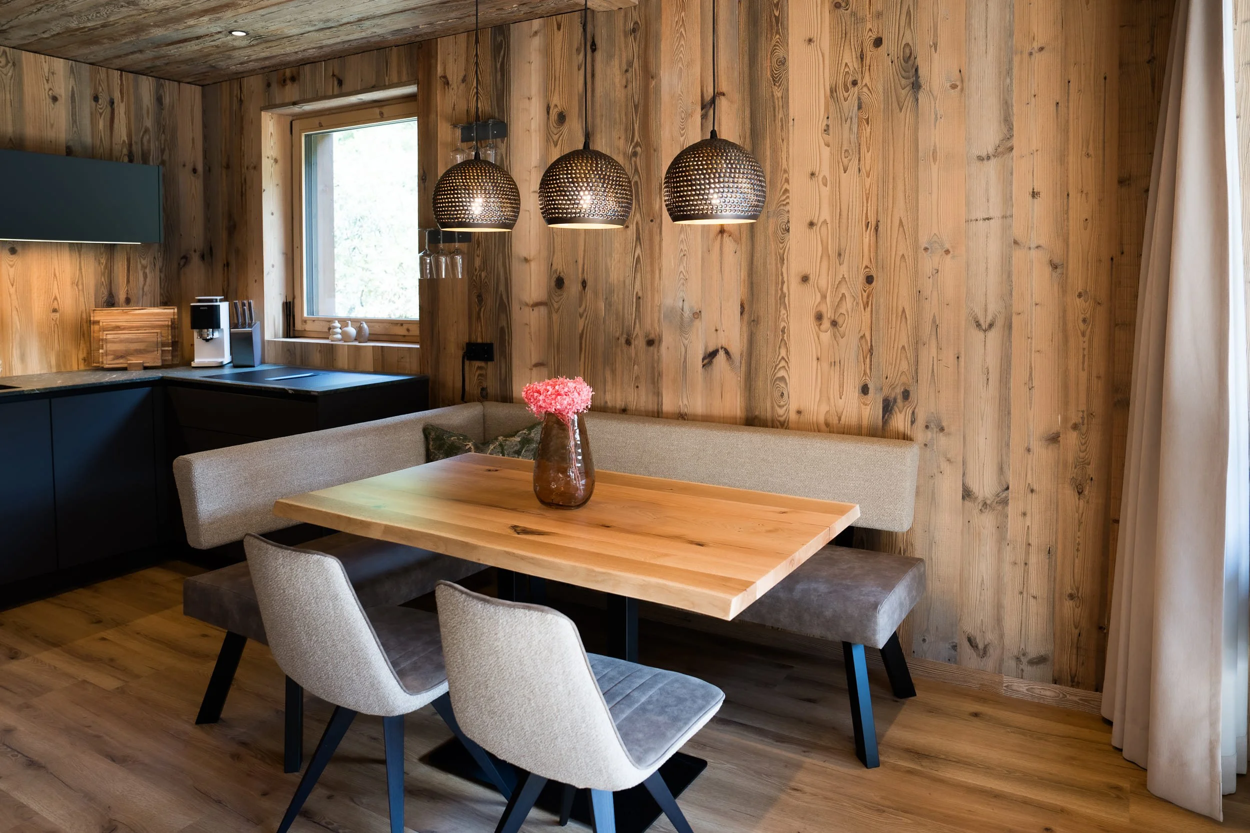 Heller Wohn- und Essbereich im SLØW Chalet mit moderner Einrichtung und großflächigen Fenstern.