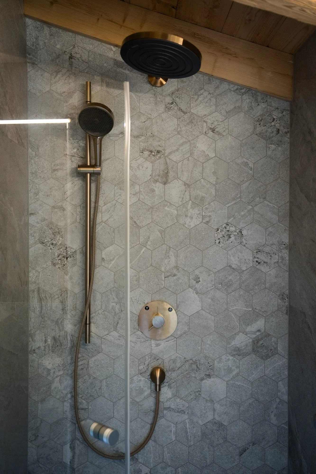Ein Badezimmer mit Holzwänden, einem großen spiegel und einer modernen Waschbeckenanlage.