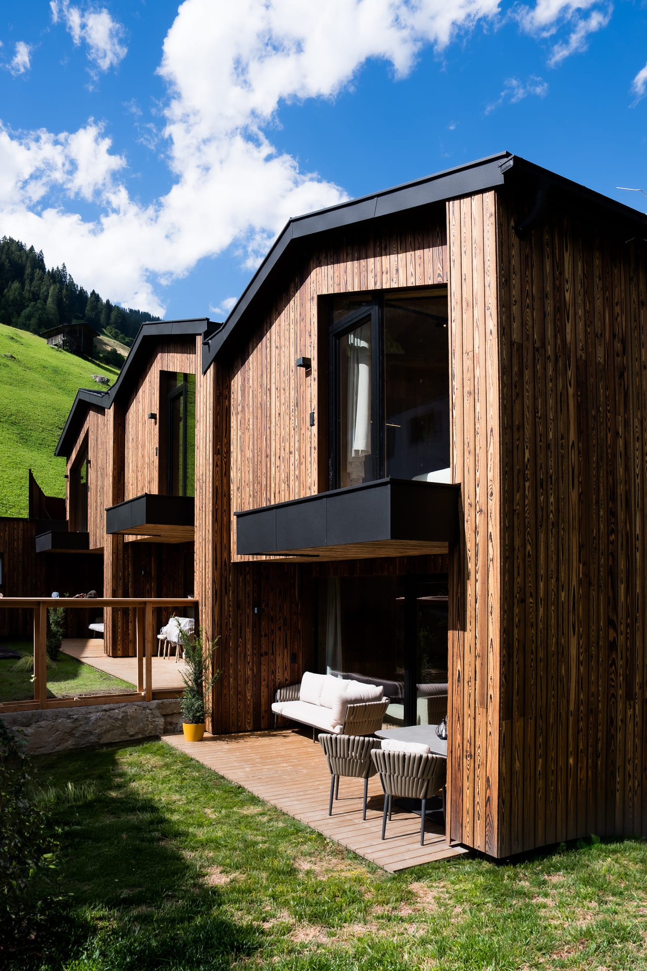 Außenansicht des SLØW Chalets mit privater Terrasse und Blick auf die Tiroler Berglandschaft.