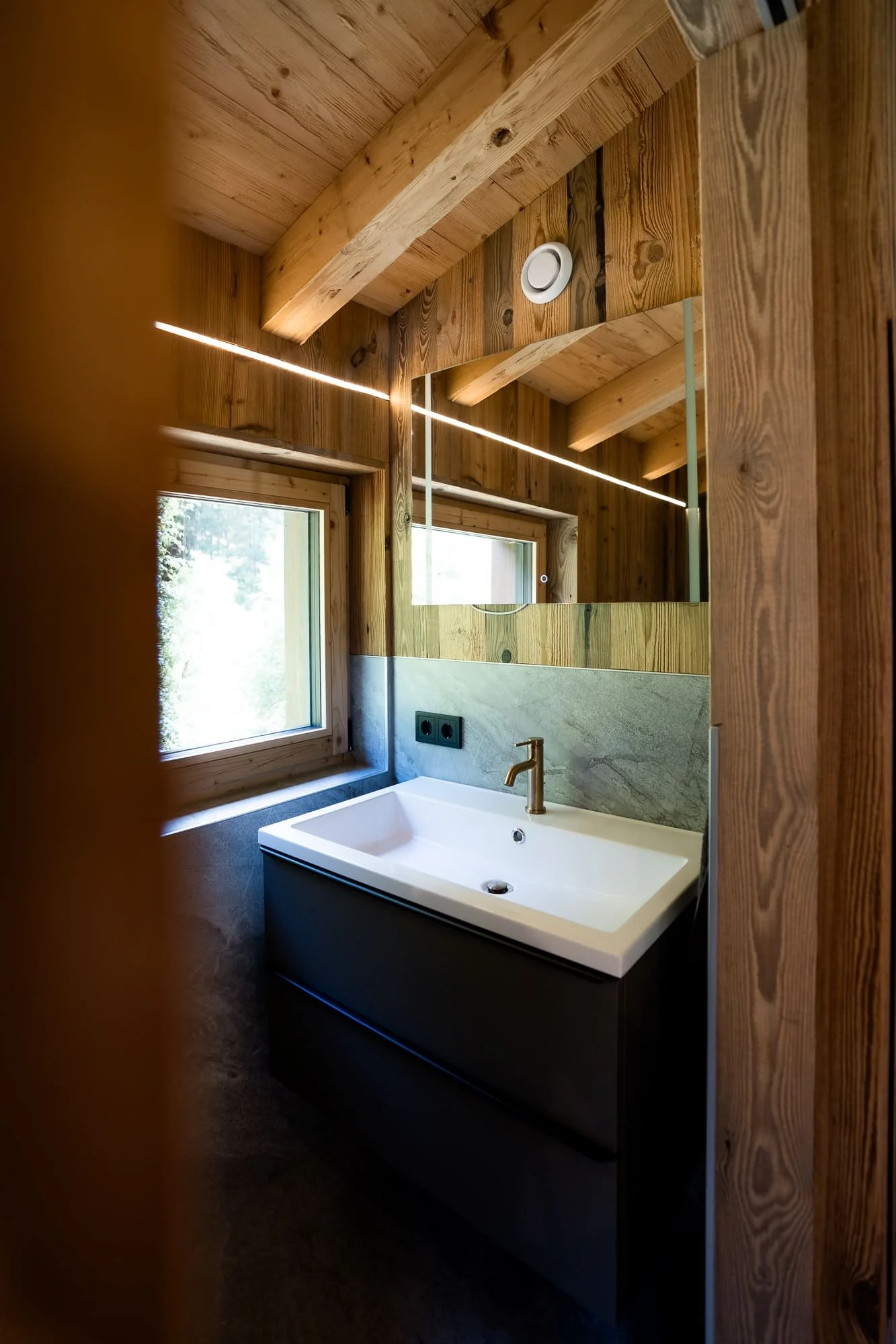 Modernes Badezimmer mit Regendusche im SLØW Chalet.