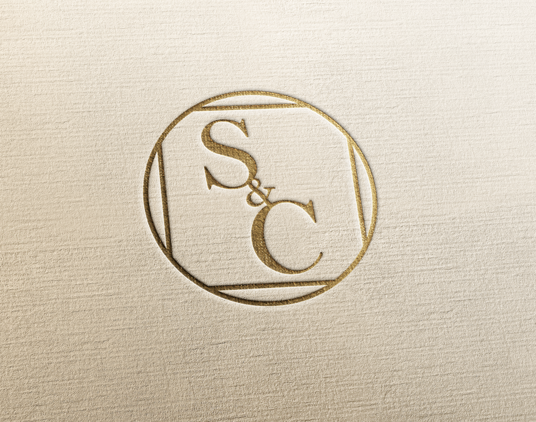 Logo doré avec les lettres S et C reliées, dans un cercle, sur fond beige.