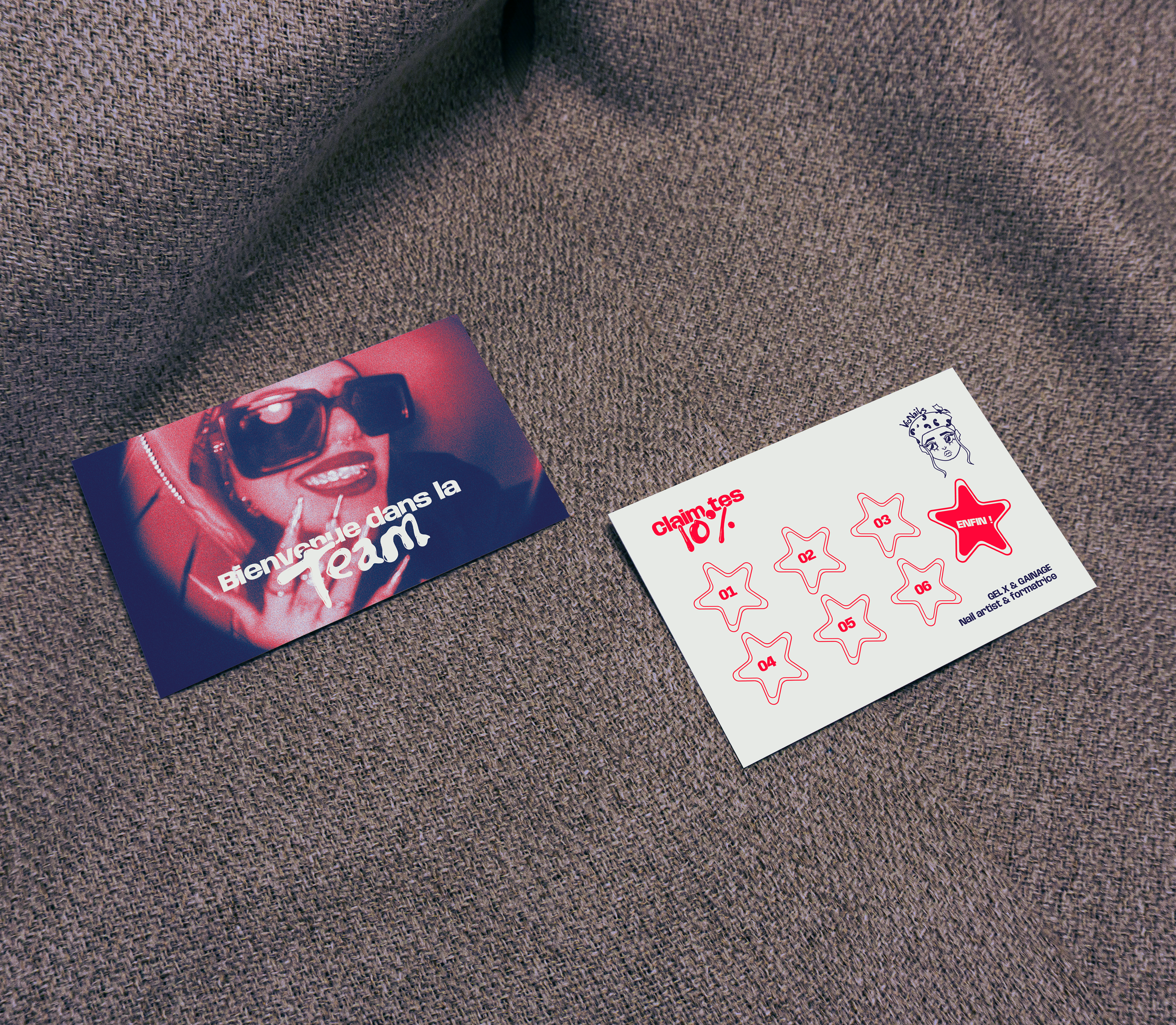 Deux cartes posées sur un tissu beige. La carte à gauche montre une femme portant des lunettes de soleil et des bijoux, avec le texte "Bienvenue dans la Tann". La carte à droite comporte des étoiles numérotées, avec le texte "claim tes 10 %" et un dessin en haut à droite.