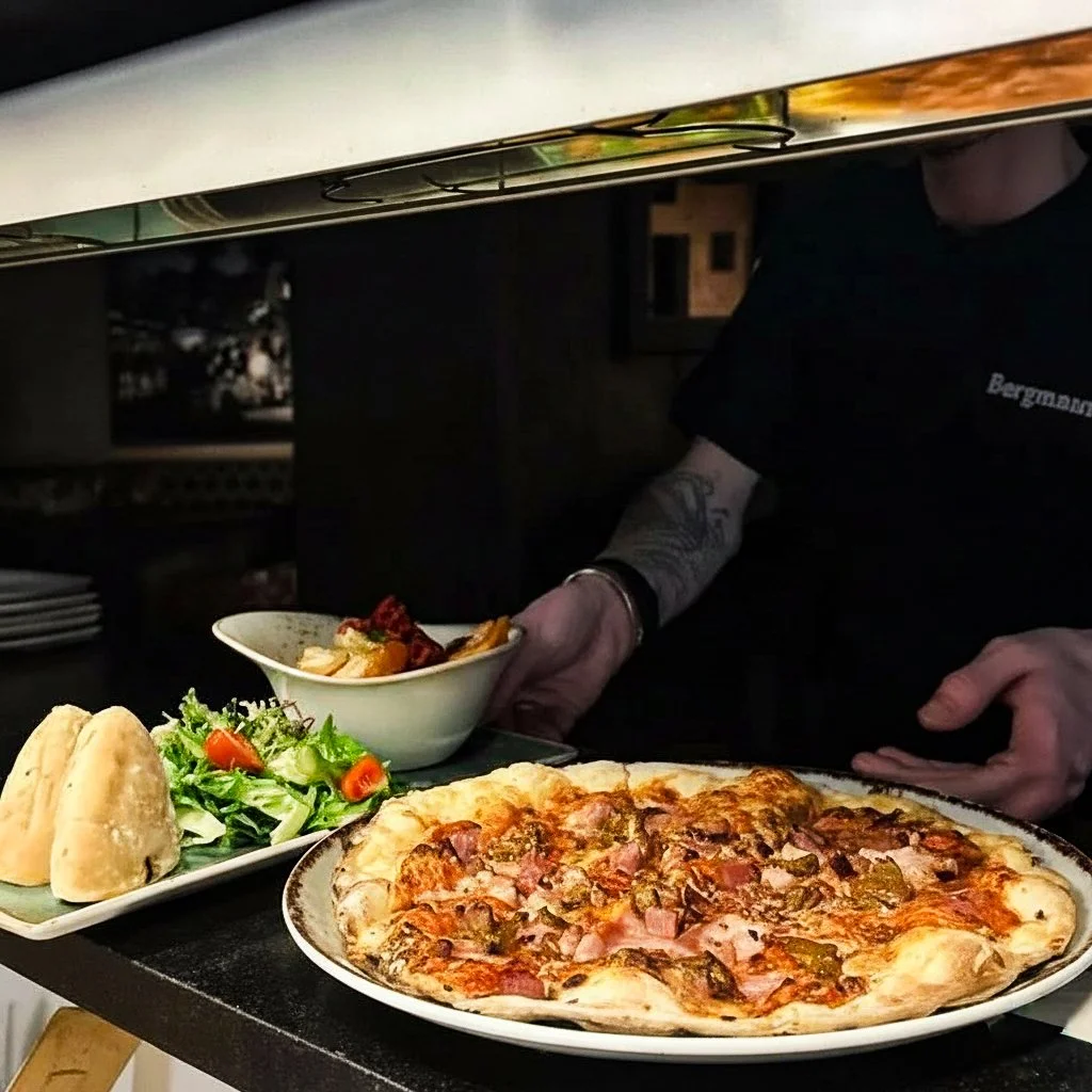 Bilde av en hel pizza med salat og brød hos Kystkroa Bar og Restaurant