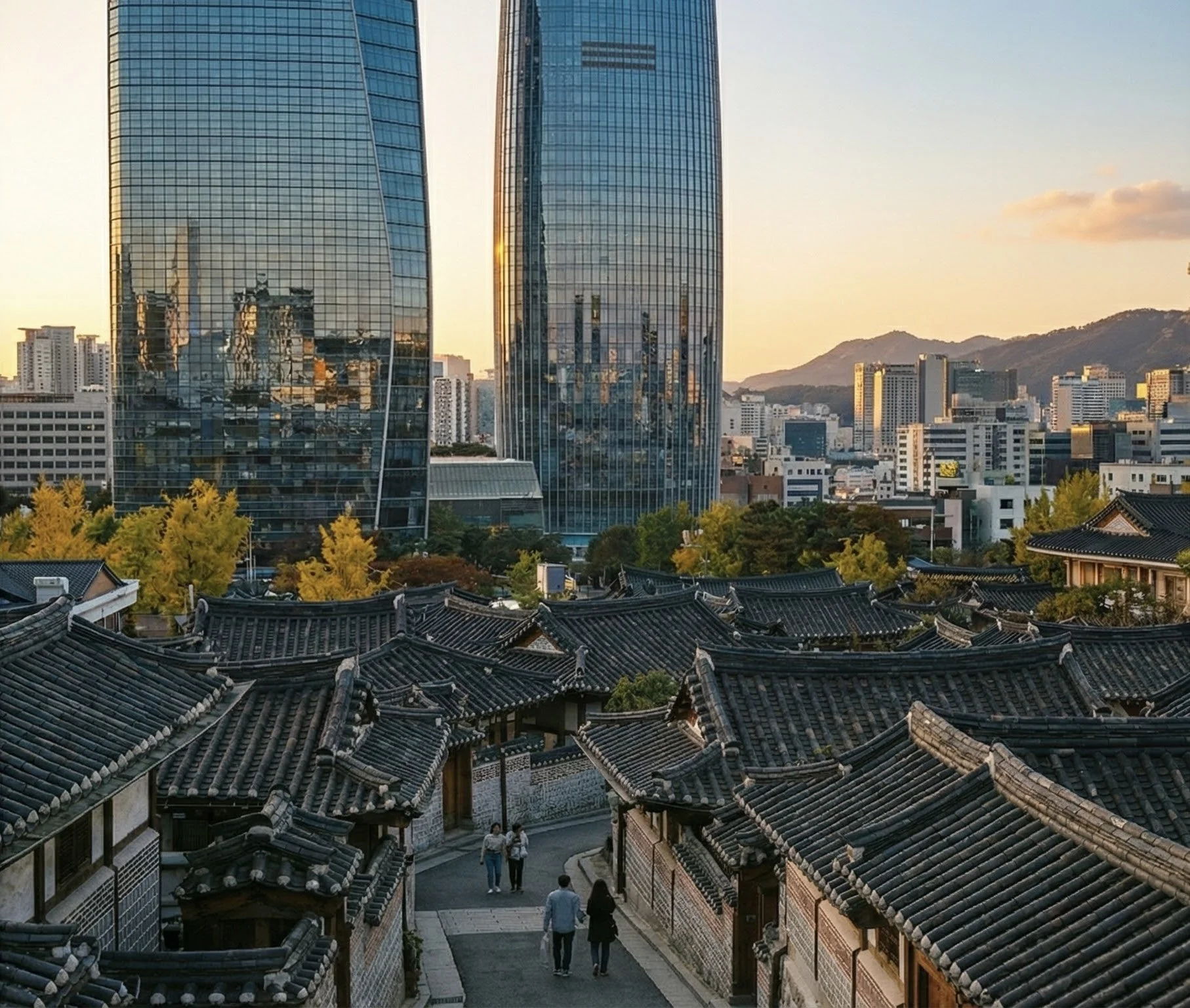 Cityscape with traditional Korean rooftops in the foreground and modern glass skyscrapers in the background during sunset.
