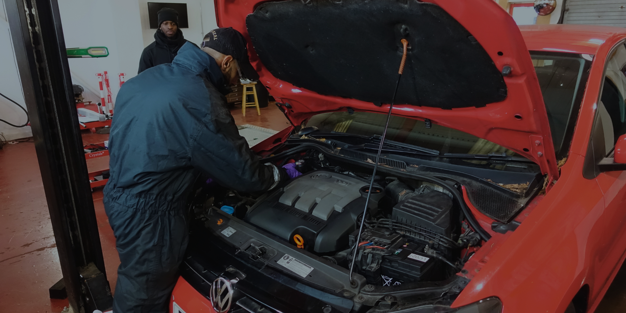 Man in car garage performing an MOT