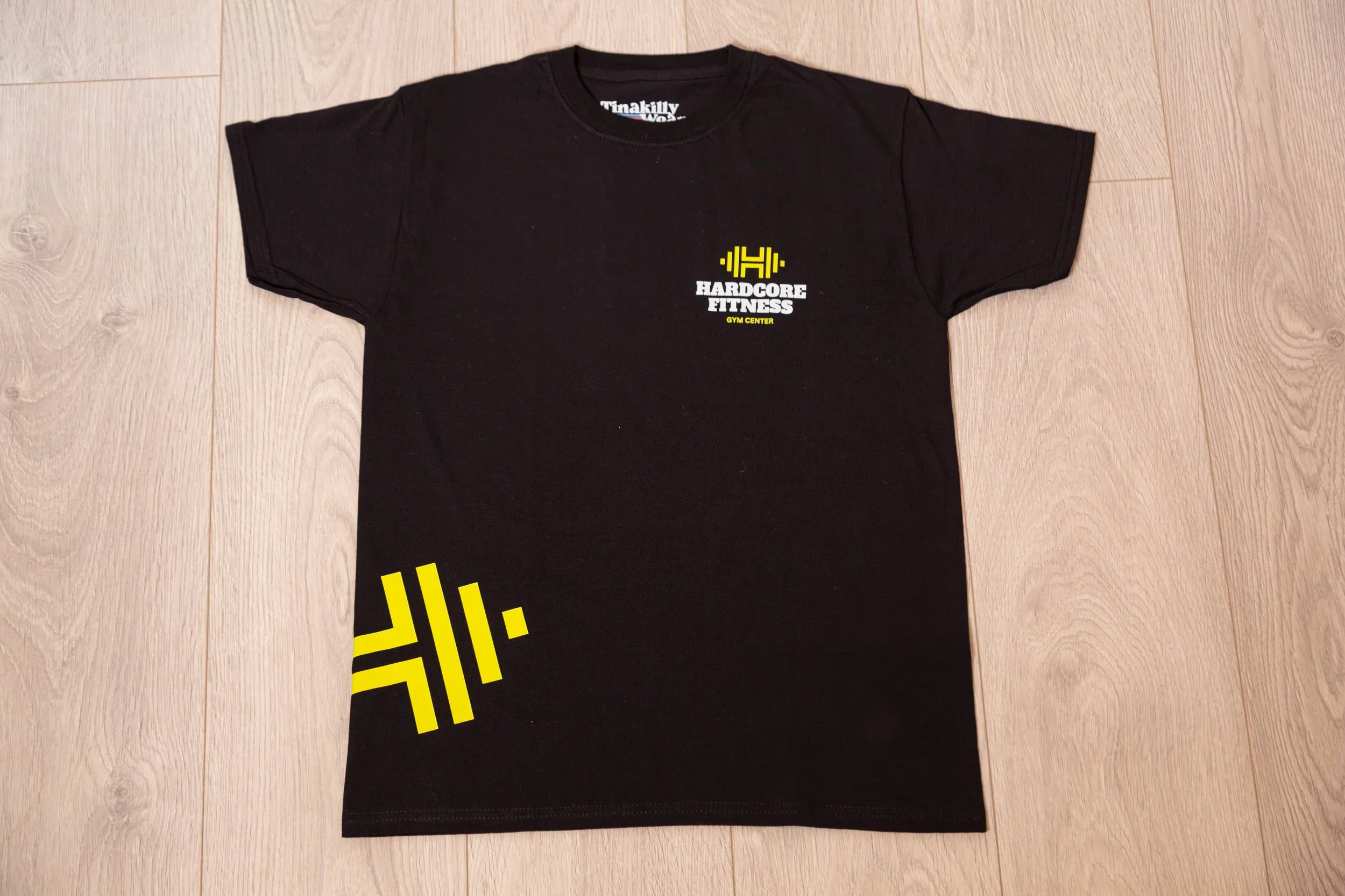 Black T-shirt with yellow and white logo and text for Hardy Fitness gym.