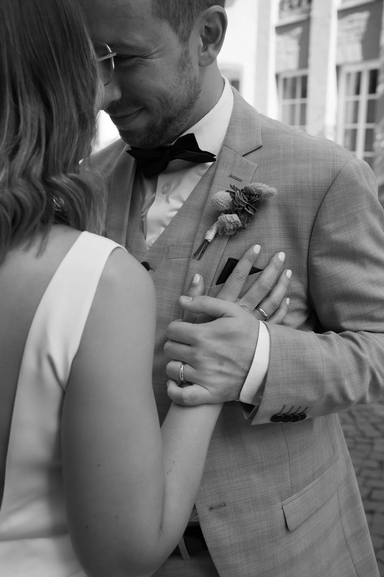 Ein Hochzeitsbild eines Paares, das sich liebevoll berührt, in Schwarz-Weiß aufgenommen.