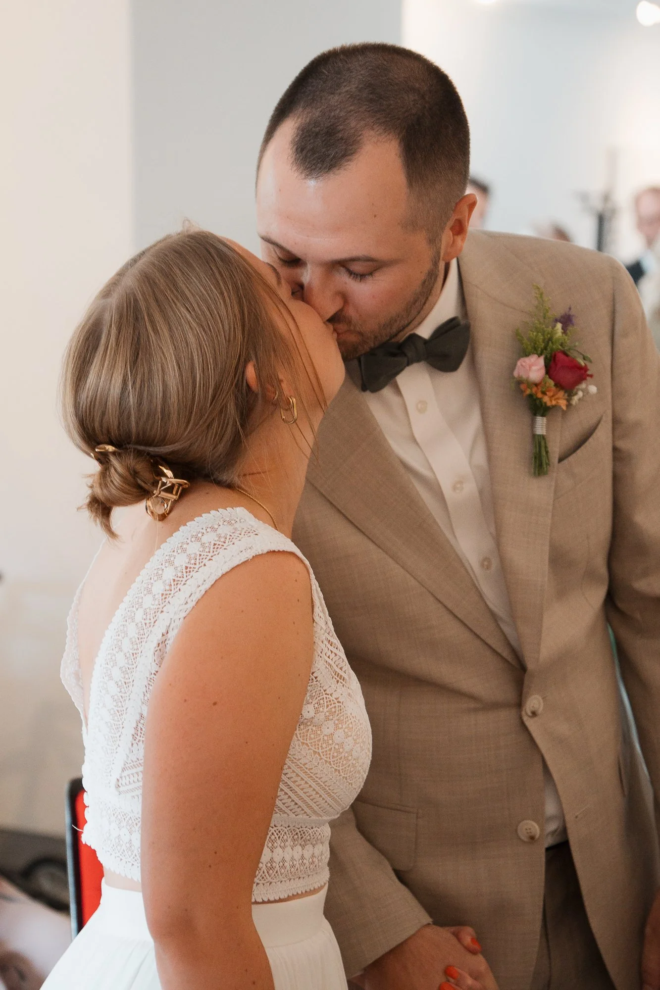 Ein Paar bei einer Hochzeitszeremonie, das sich küsst.