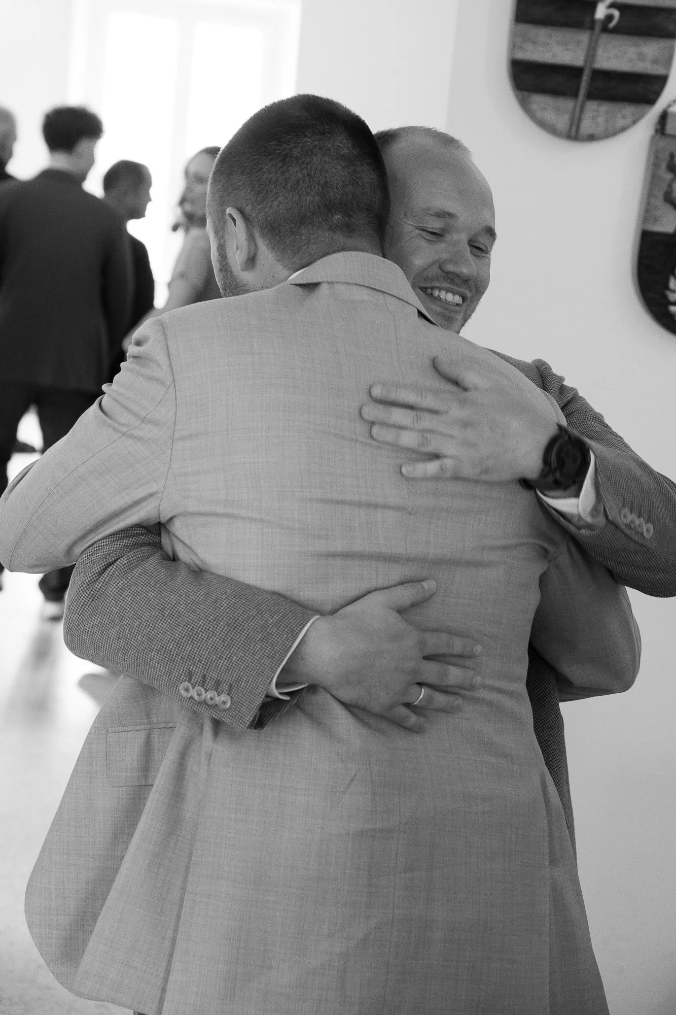 Zwei Männer umarmen sich freudig bei einer Begrüßung.