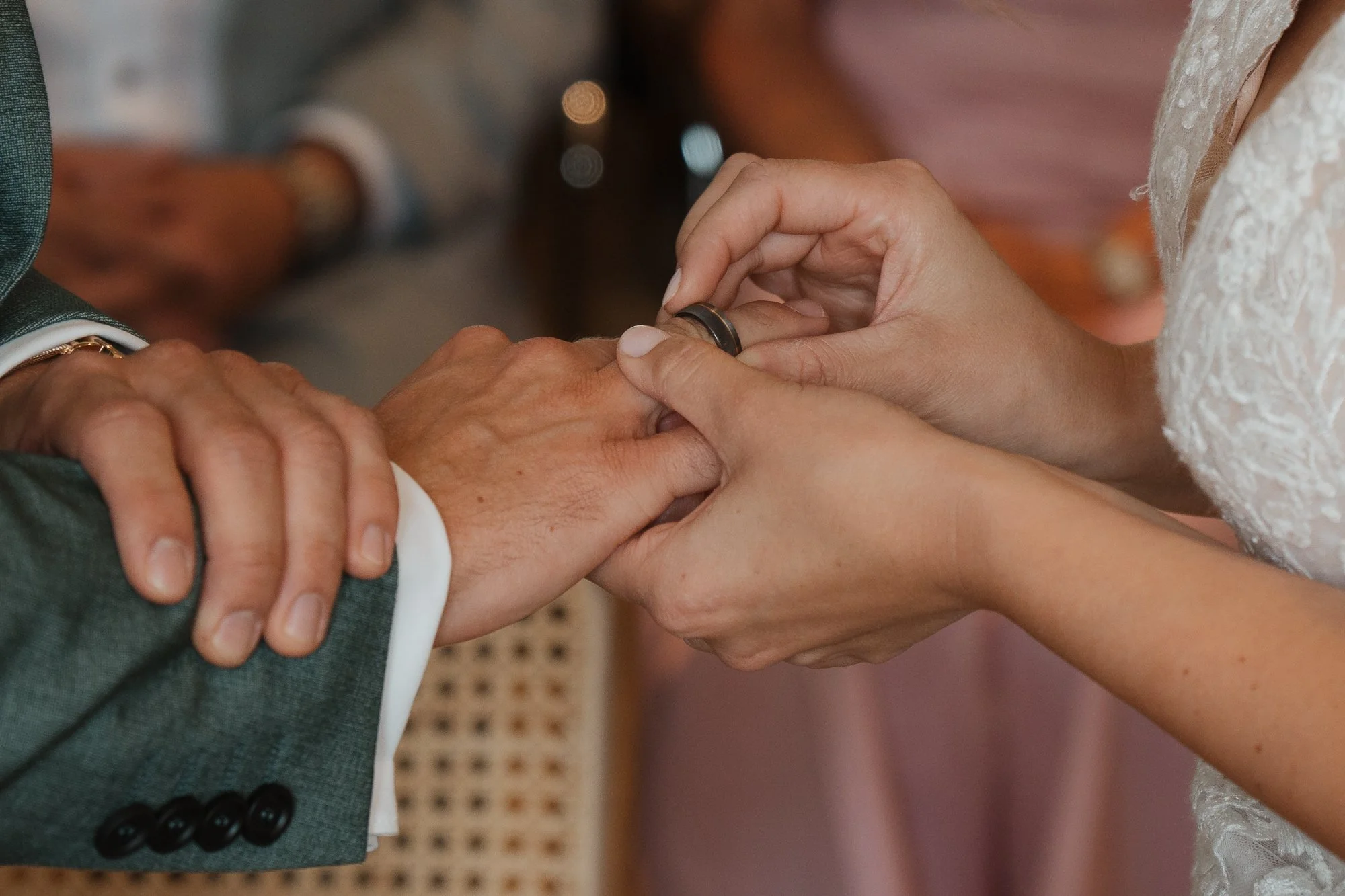 Ein Brautpaar tauscht Eheversprechen bei einer Hochzeit, die Braut steckt dem Bräutigam den Ehering an.