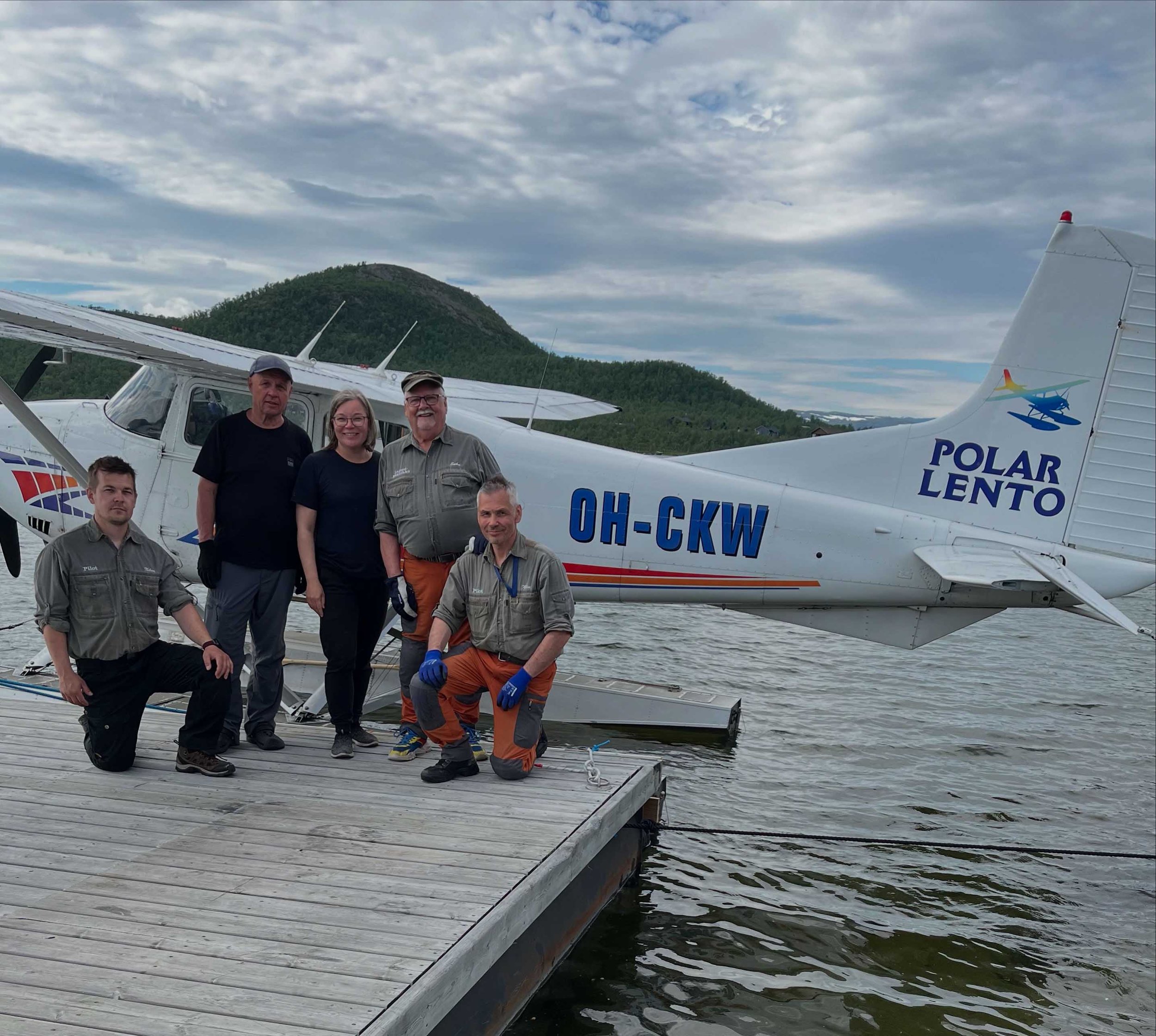 Hymyilevä Polar-Lento Oy:n tiimi laiturilla rantautuneen koneen edessä.