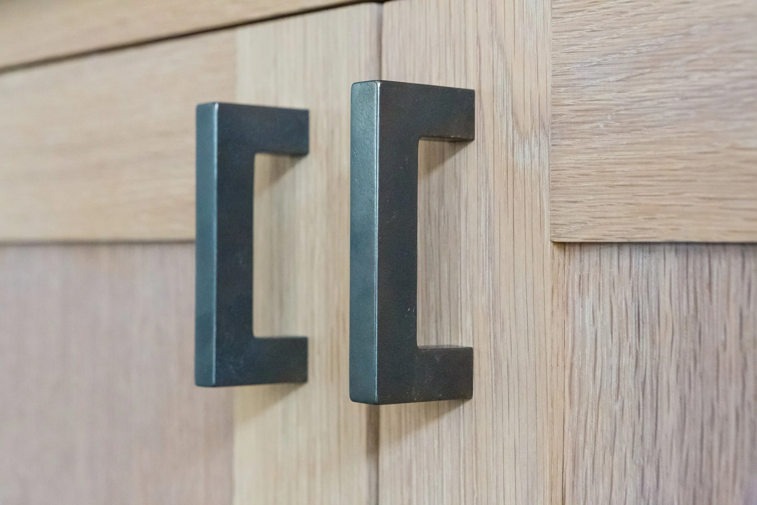 Close-up of black metal door handles on a wooden door