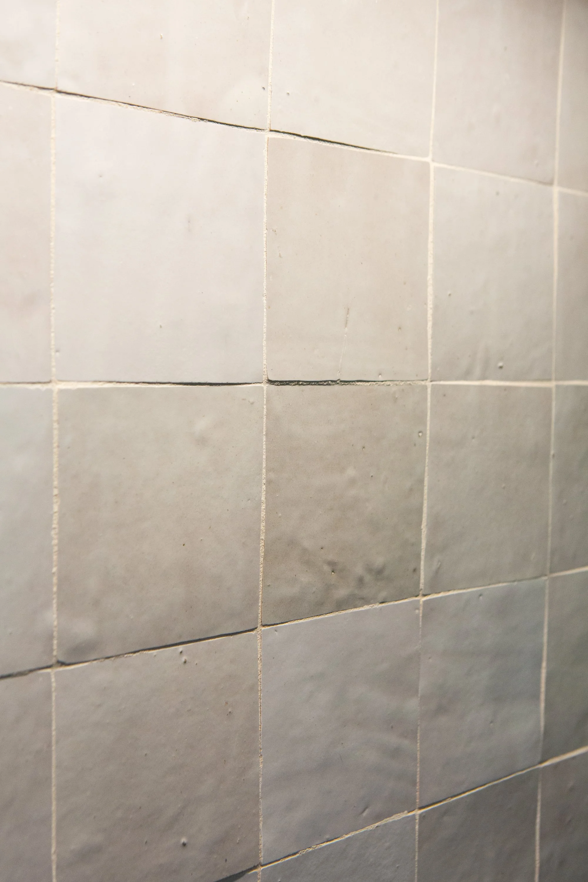 Close-up of beige ceramic tiles with visible grout lines.