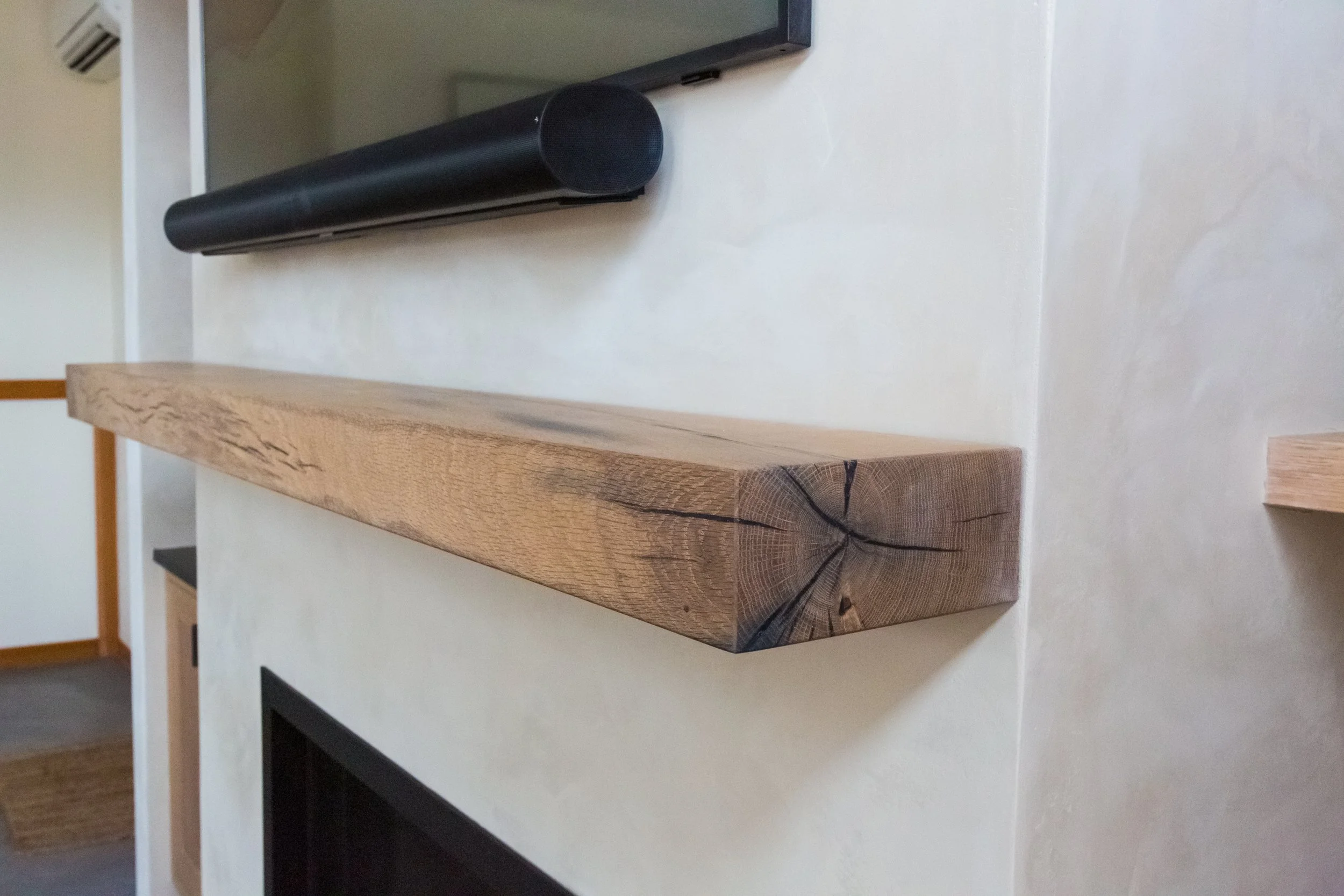 A wooden slab with visible growth rings placed on a white surface.