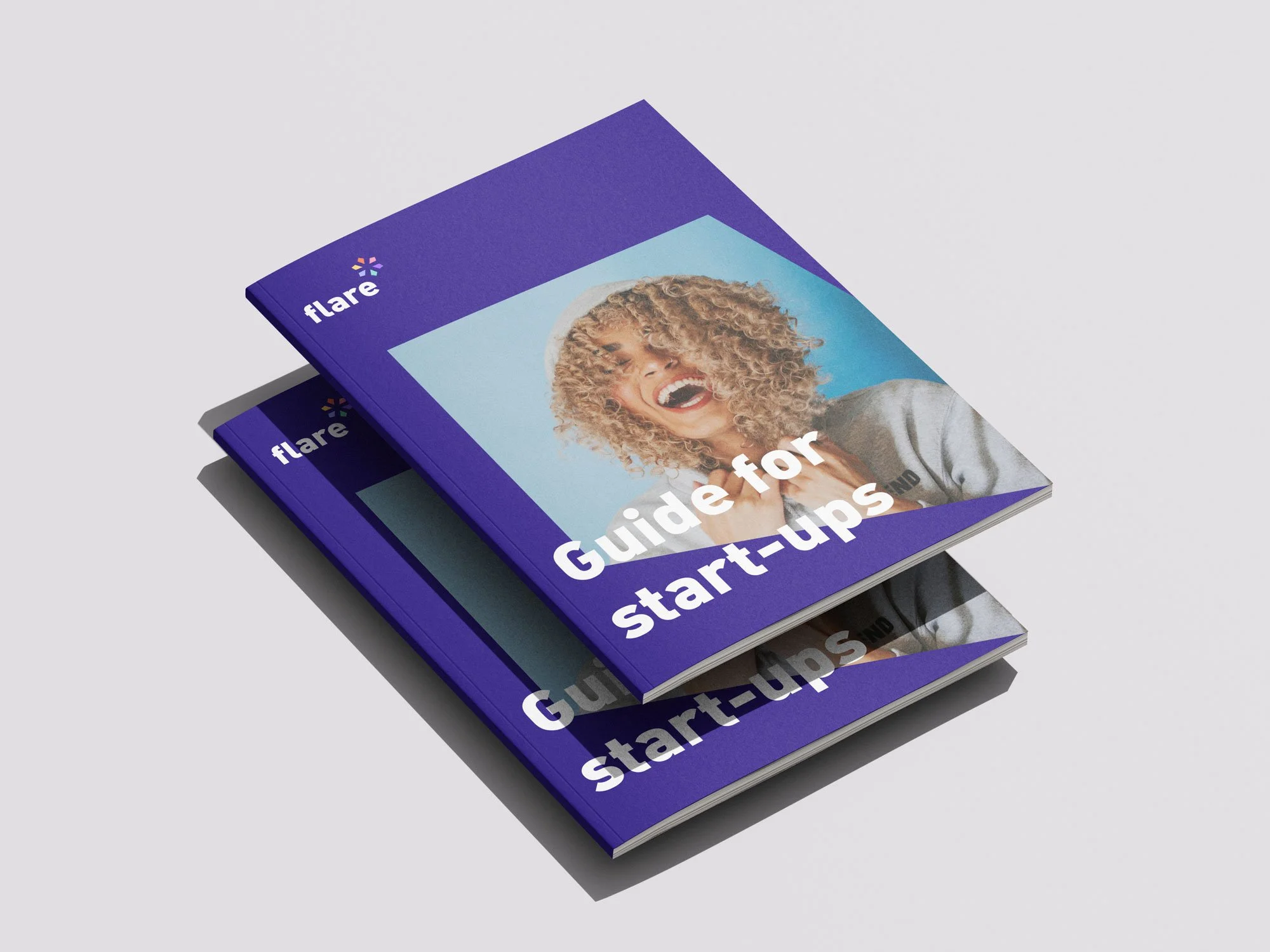 Two purple booklets titled "Guide for start-ups" with a smiling woman on the cover, on a white background.