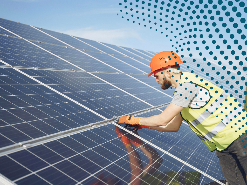 Image of a man installing solar panels wearing PPE