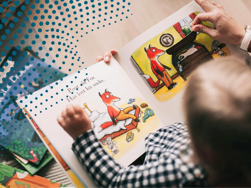 Image of a toddler from above, reading a children's book.
