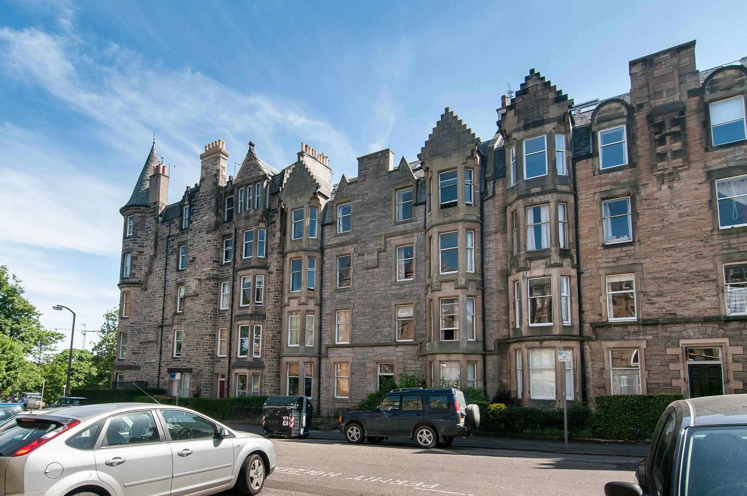 Kitchen with wooden cabinets, stainless steel appliances, including a range, microwave, and refrigerator, and a small dining table with chairs.