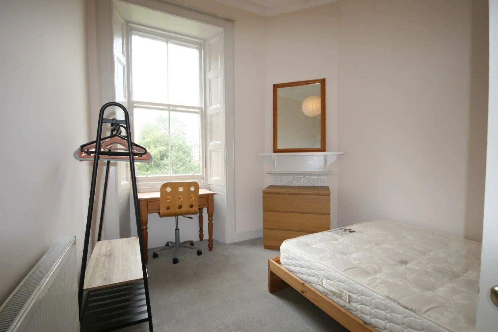 Church building on a hillside with snow-capped mountains in the background and a cloudy sky.