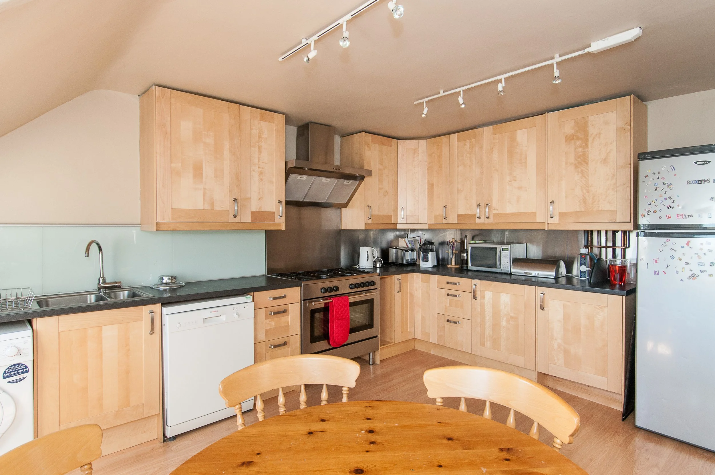 Scenic landscape of a mountainous region with a lake, green hills in the foreground, and cloudy sky overhead.