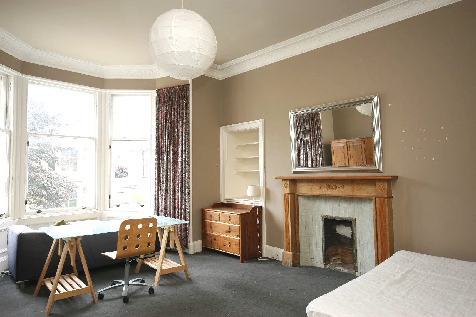 A landscape with elliptic trees scattered across a bright green field, under a cloudy sky.