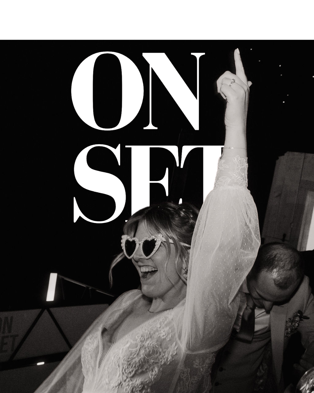 A woman wearing heart-shaped sunglasses and a lace dress is dancing and smiling with her arm raised in celebration at a wedding reception, with a man in a suit in the background & the words onset behind.