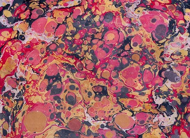 Abstract marbled pattern with swirls of pink, black, red, yellow, and white.
