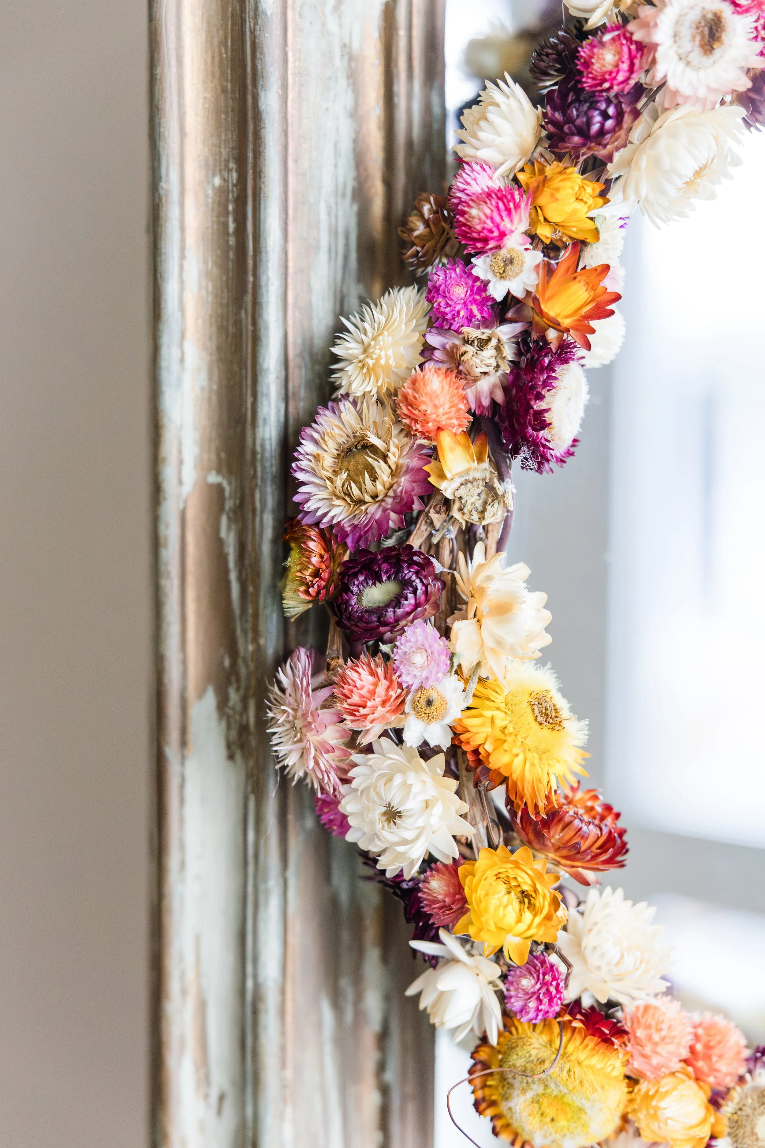 Couronne de fleurs sechees accrochee a un miroir