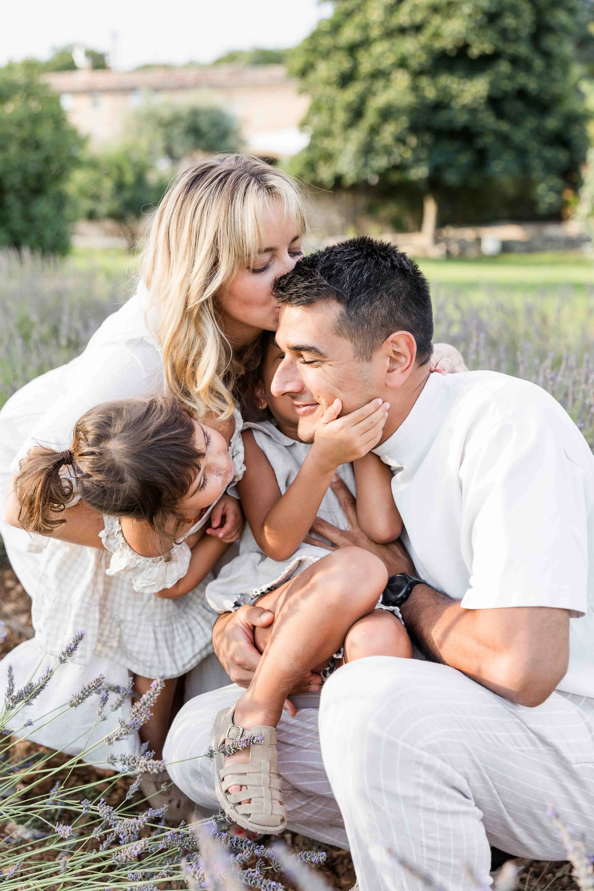 Parents partageant un moment complice avec leurs enfants pendant une séance photo famille en Provence