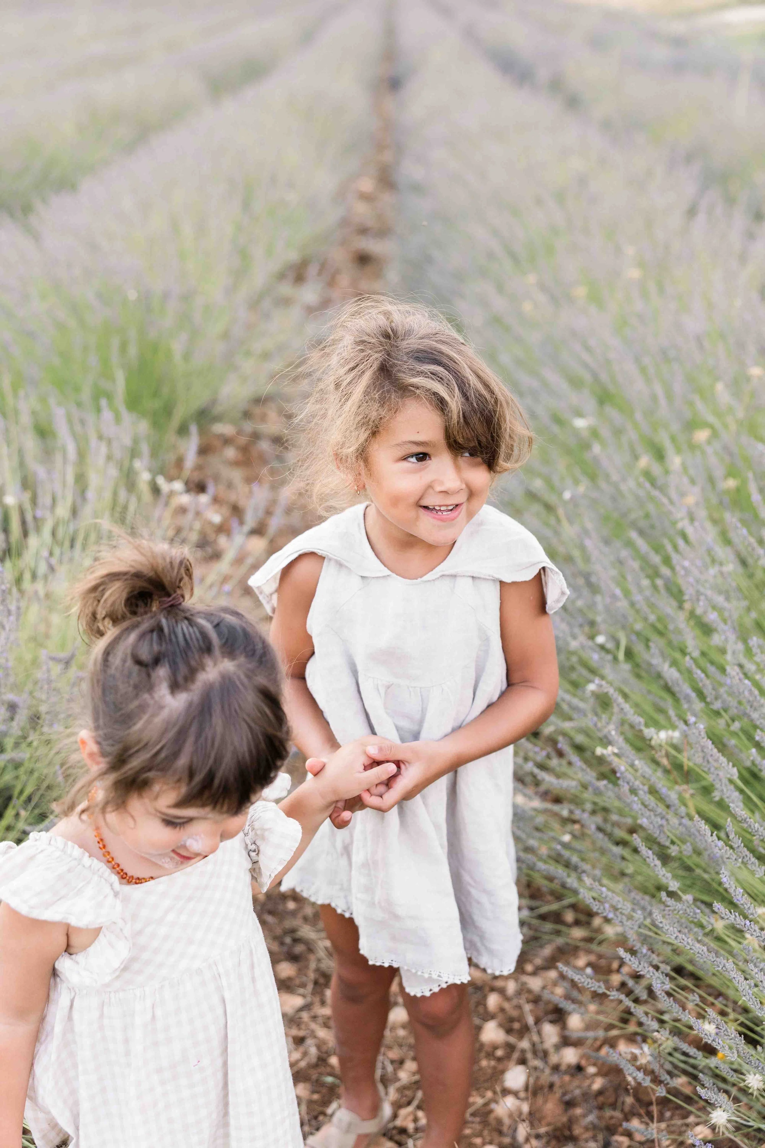 Sœurs en robe blanche dans un champ de lavande pendant une séance photo famille Provence