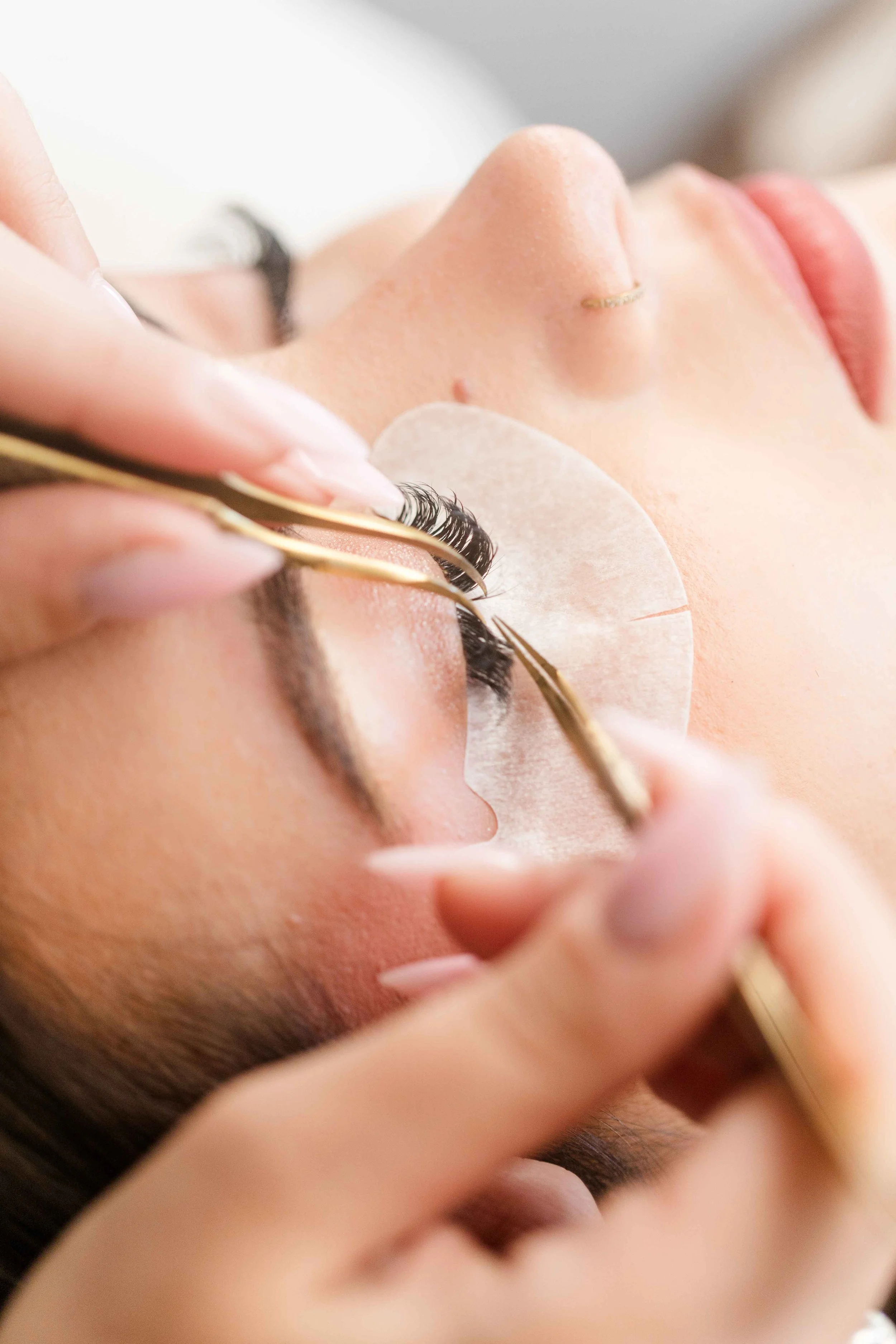 photo d'une esthéticienne en train de poser des cils dans son institut à salon de provence pendant une séance photo branding avec audrey photographie