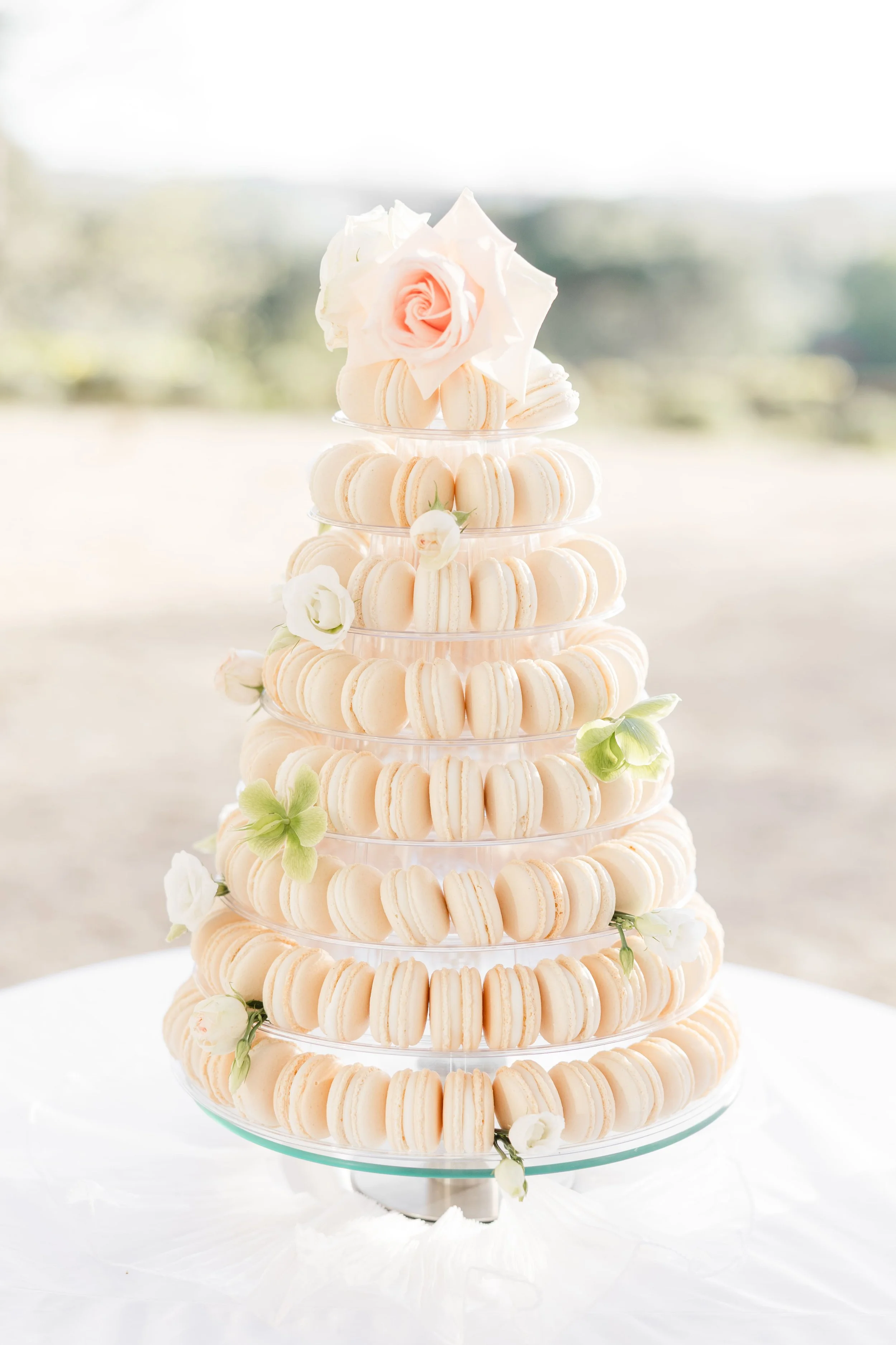 Pièce montée de macarons blancs et dorés élégamment dressée pour la réception de mariage.