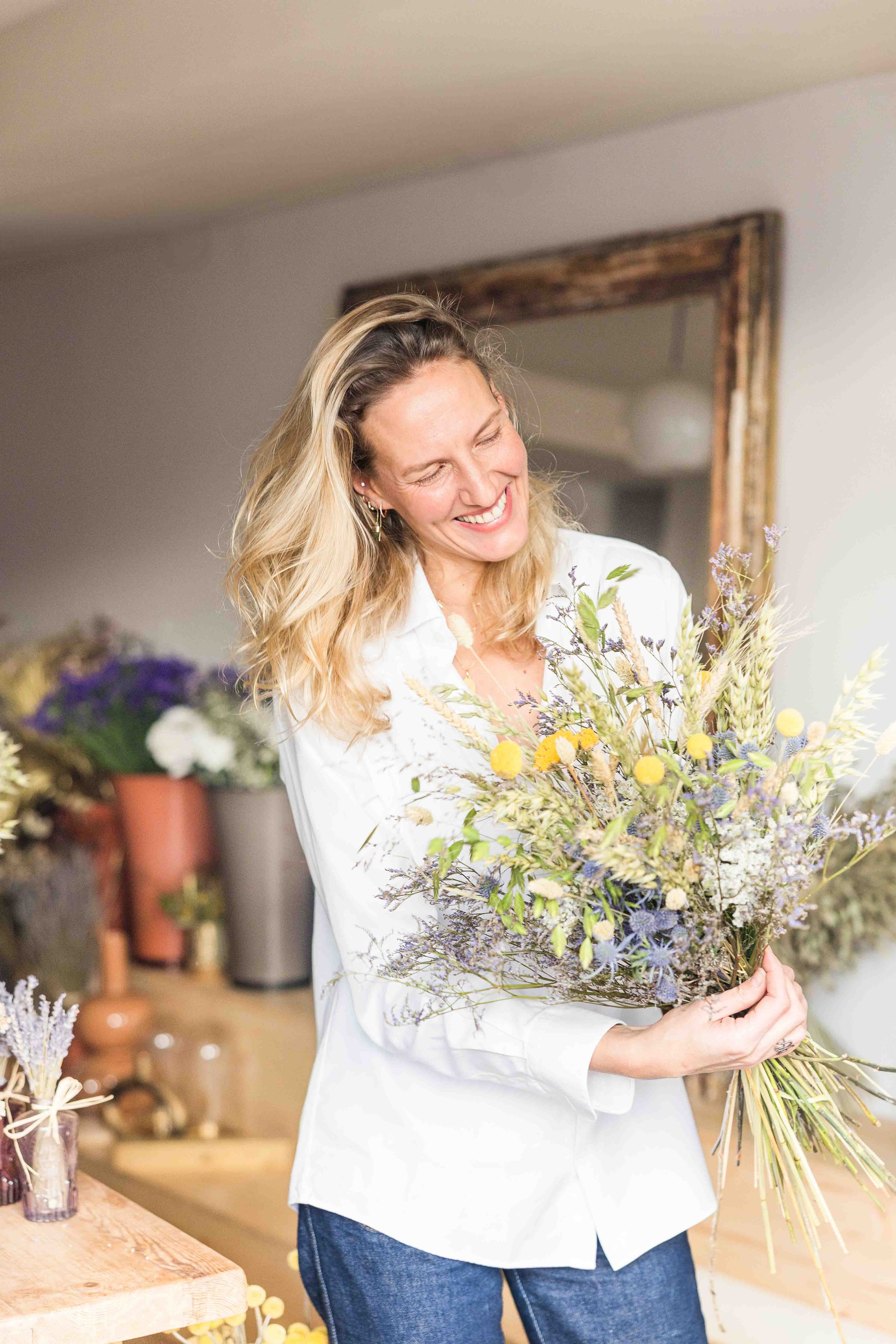 Artisan fleuriste Tiara Comte composant un bouquet de fleurs sauvages et séchées en Provence