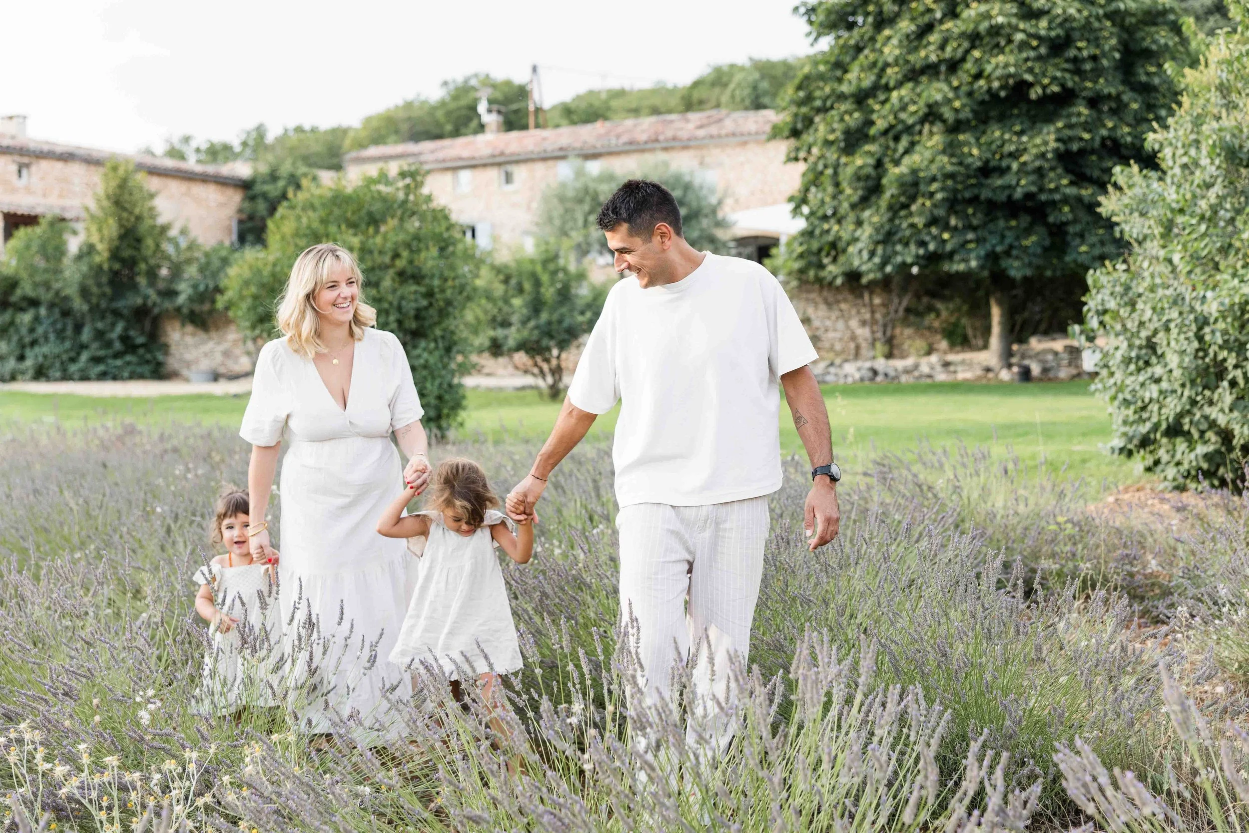 famille qui marche dans un champ de lavande lors d'une séance photo famille en provence avec audrey tout le monde riant et s'amusant
