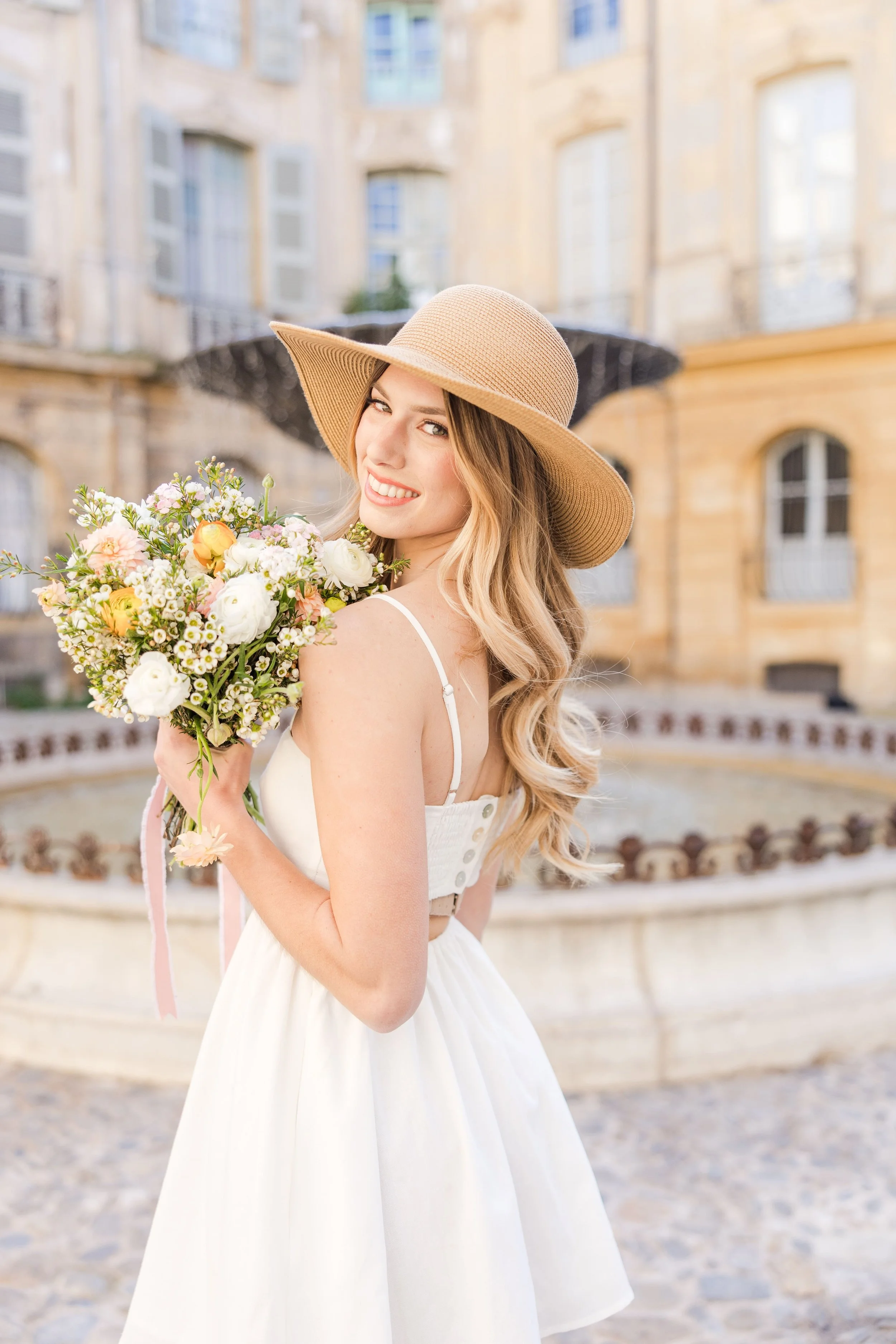 portrait d'une fille tenant un bouquet et un chapeau lors d'une séance estivale à aix en provence
