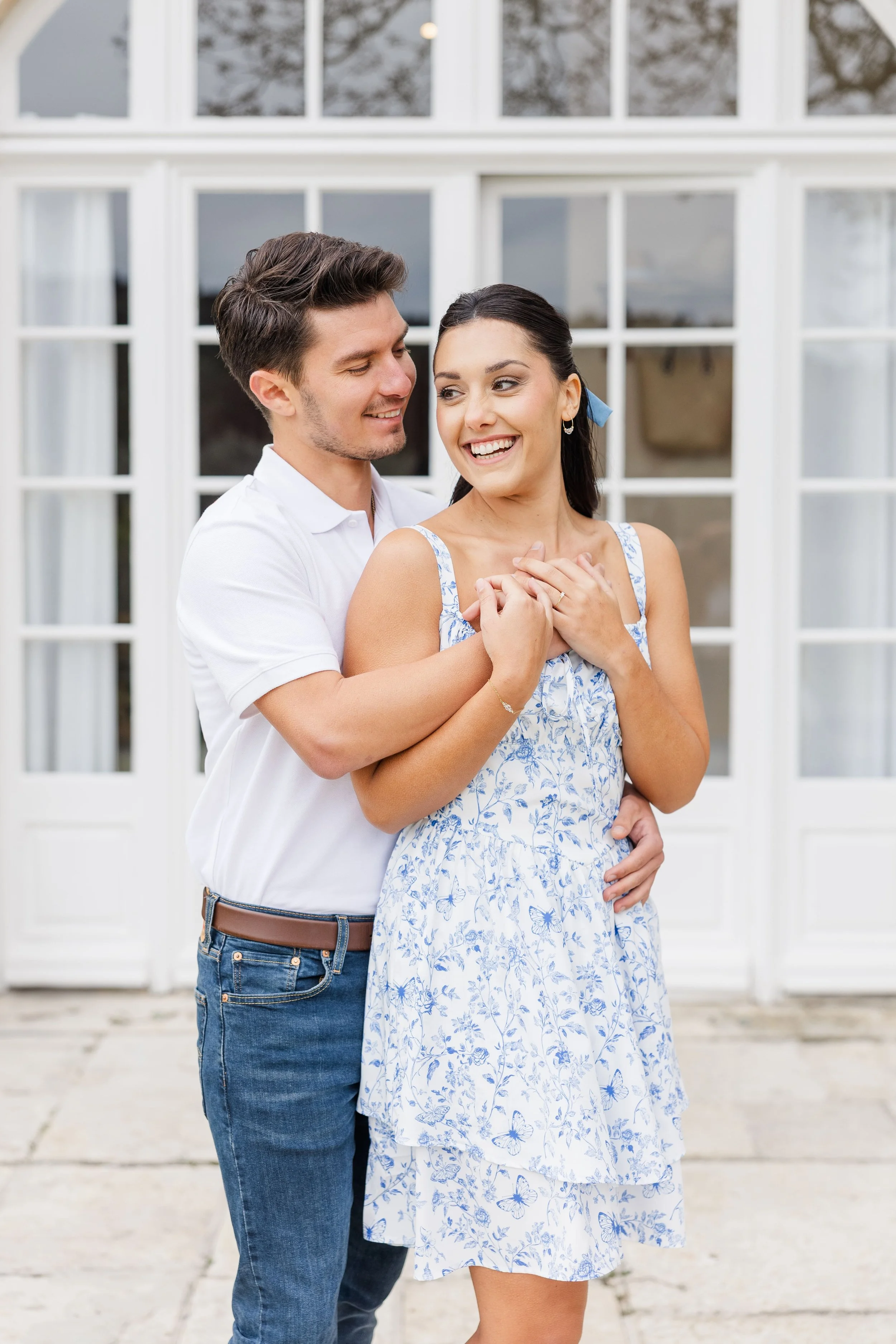 Le couple se tient devant la magnifique bastide provençale en pierre du Mas de La Rose à Orgon, entouré d'un parc arboré et d'oliviers.