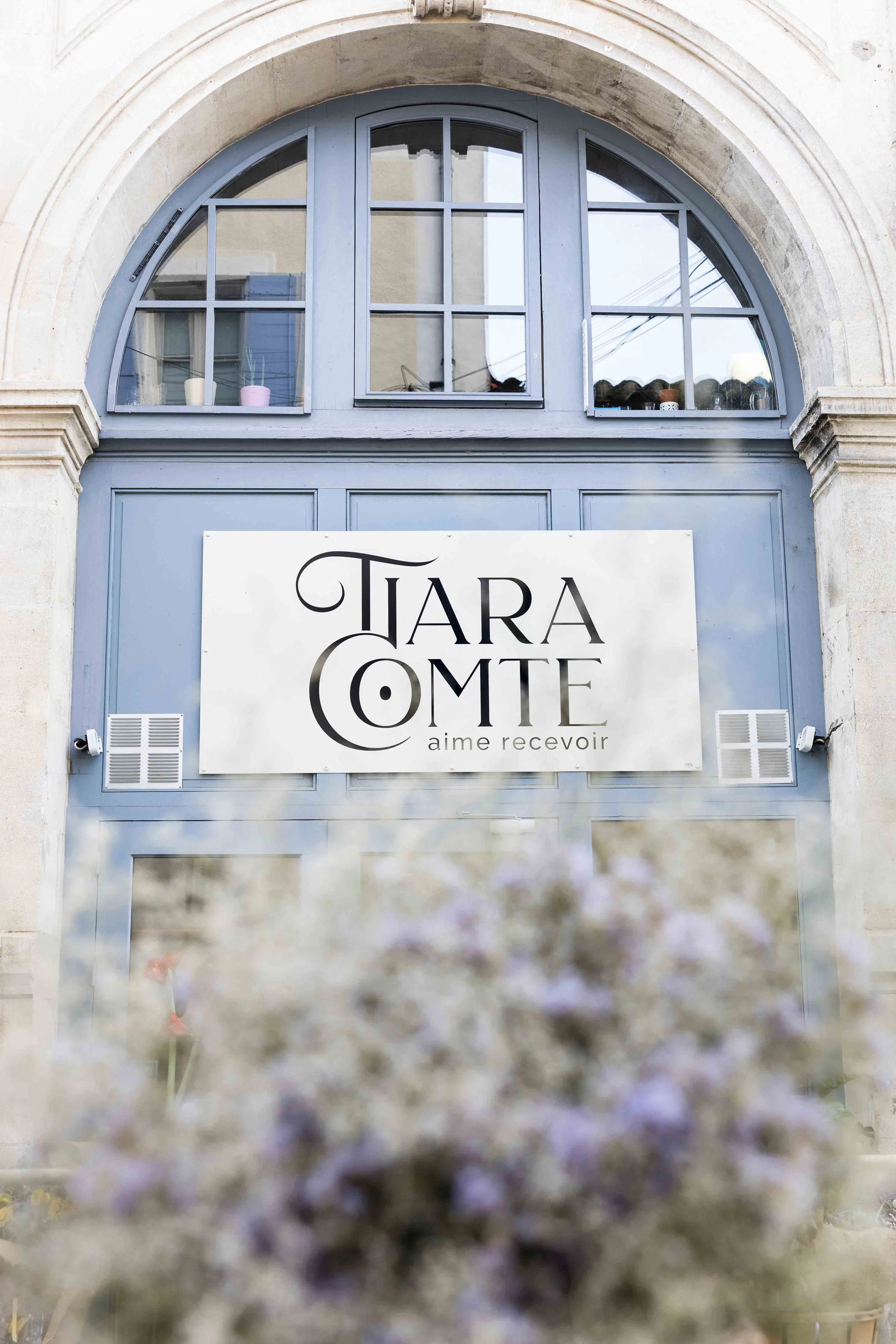 Devanture de l'atelier fleuriste Tiara Comte en Provence avec arche en pierre et enseigne