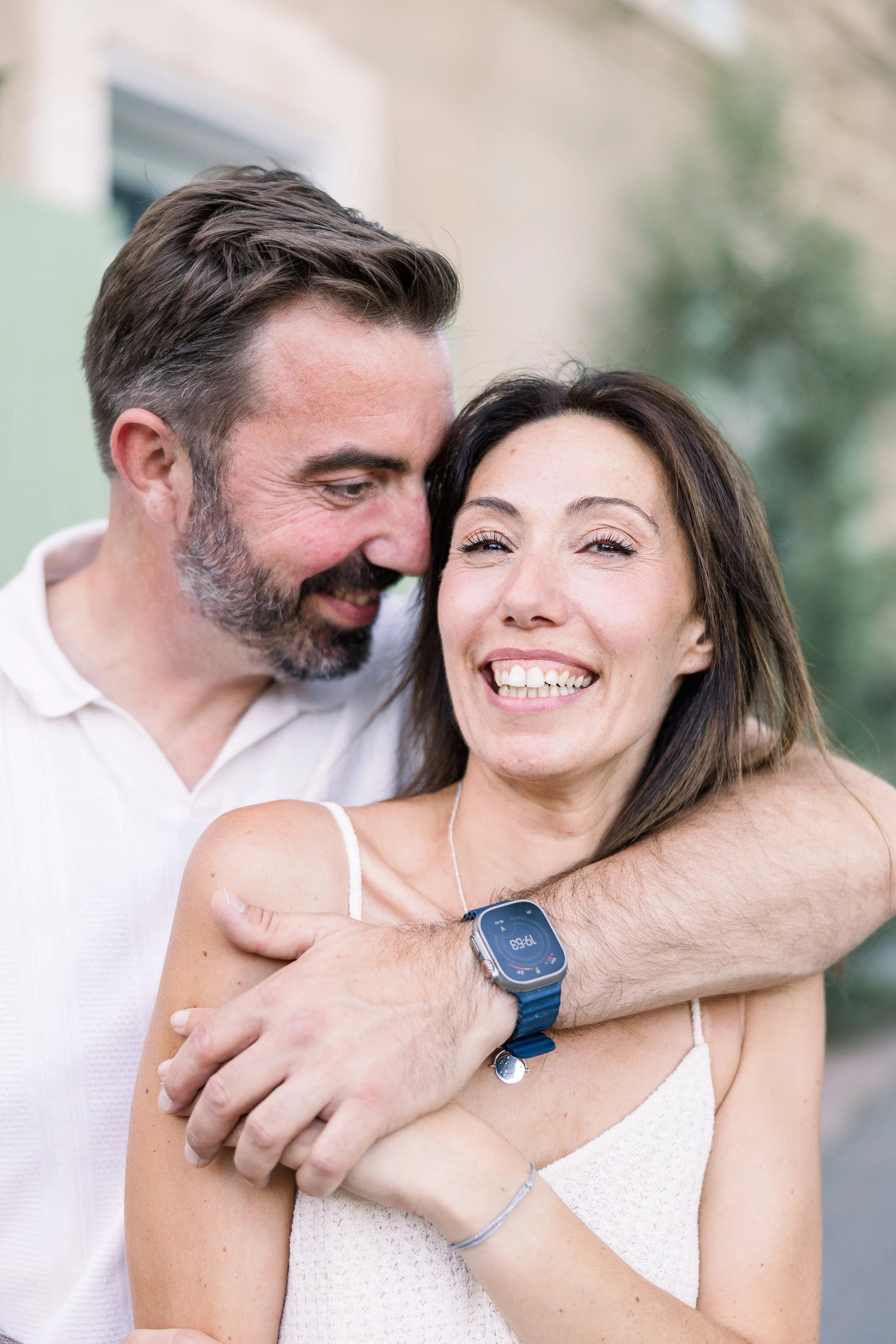 Un portrait rapproché et sincère d'un couple riant joyeusement, capturant leur bonheur authentique en Provence.