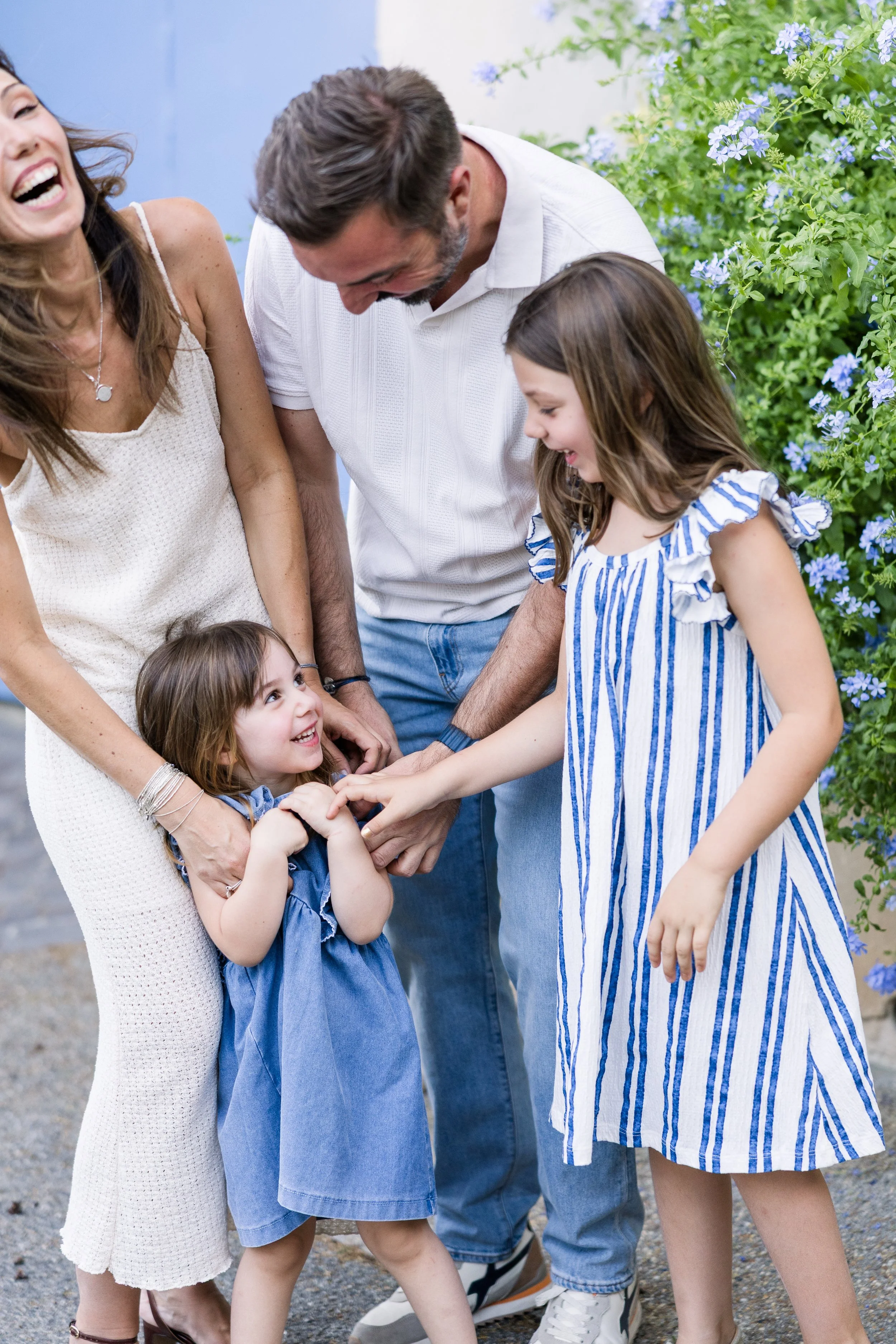 Une photo de famille décontractée et chaleureuse, où tout le monde se tient ensemble en souriant, dans un village provençal.