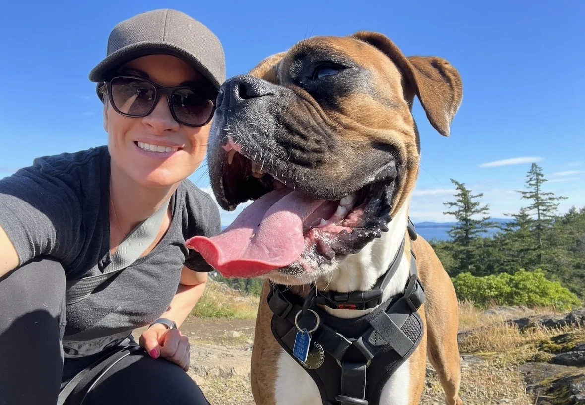 Kadoga community manager Nicole smiling beside her dog Lenny during an outdoor walk near Victoria, British Columbia.