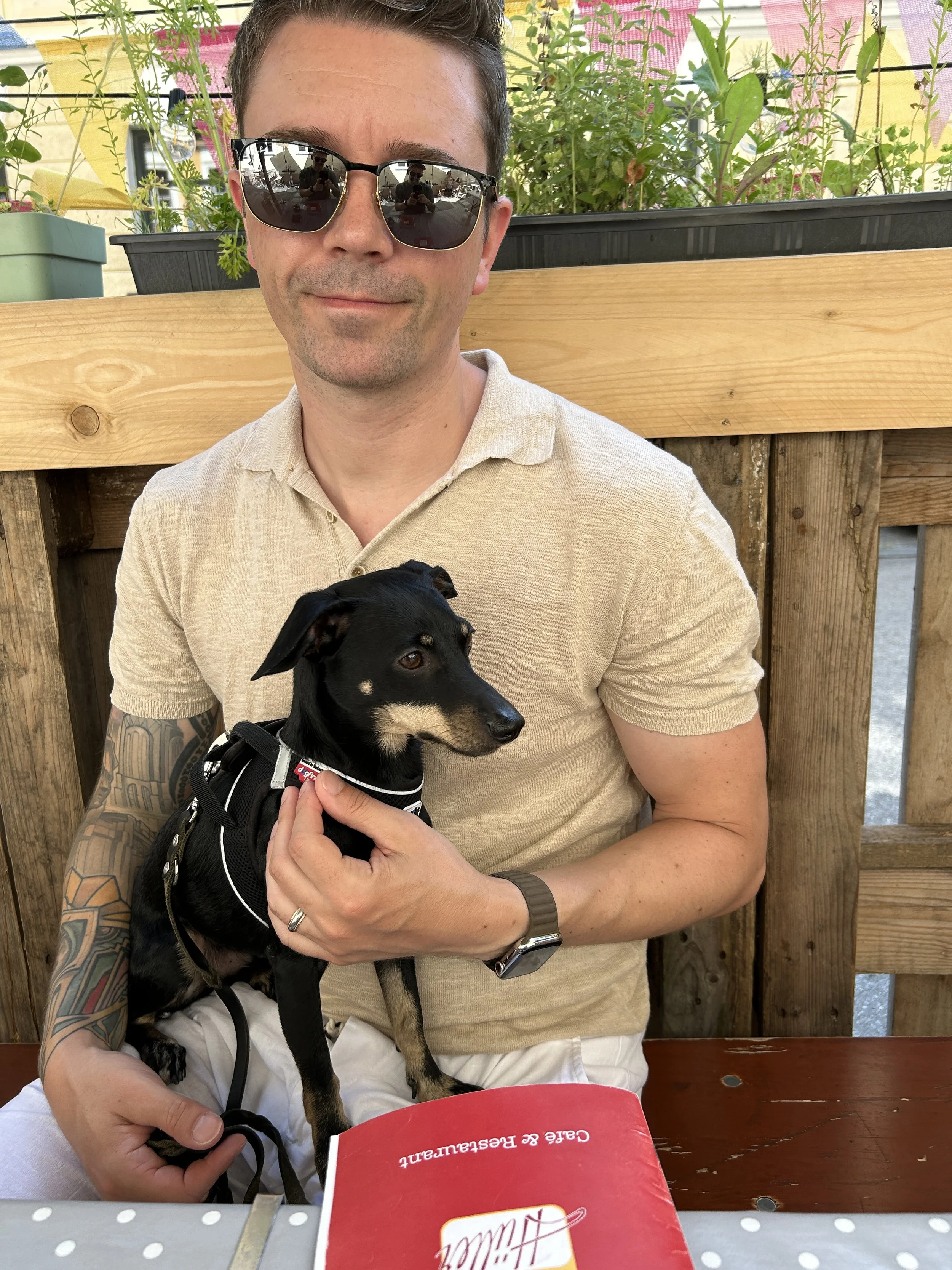 A man sitting with a mini pincher.