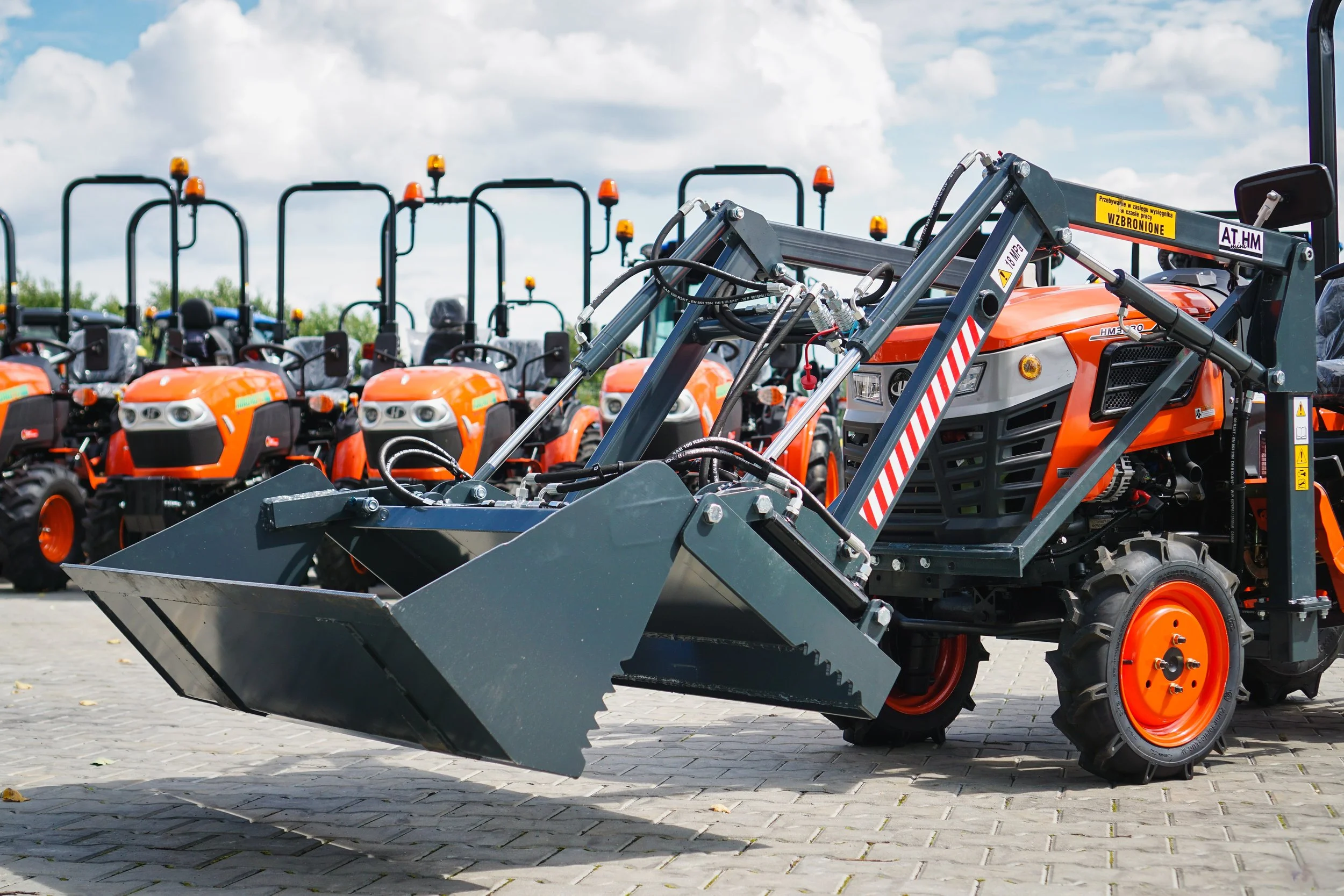 Hinomoto HM-3030, trattore con caricatore frontale multifunzionale, vista anteriore angolata