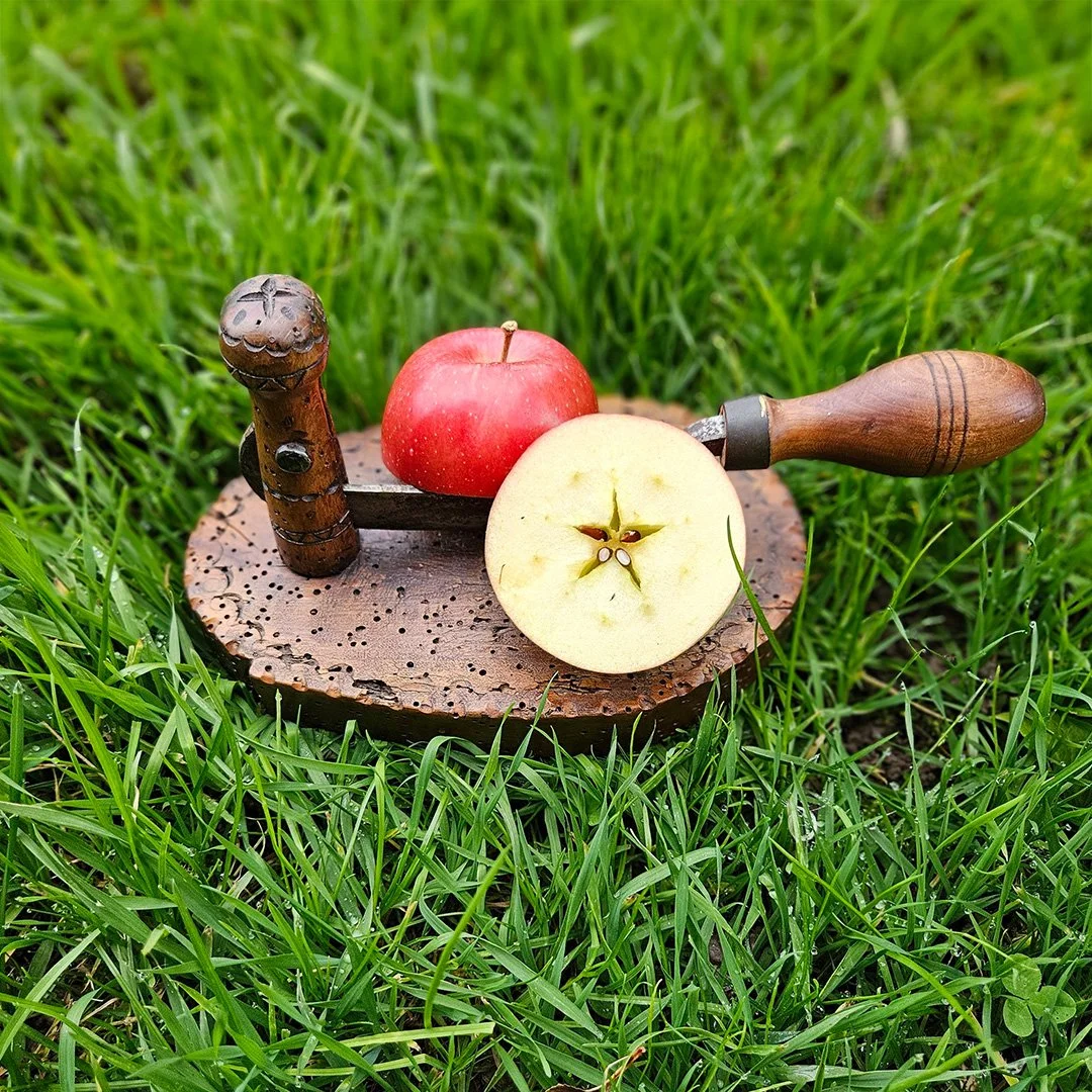 Bild eines halbierten Apfels. Im Zentrum der einen Hälfte sieht man das Pentagram des Kerngehäuses.