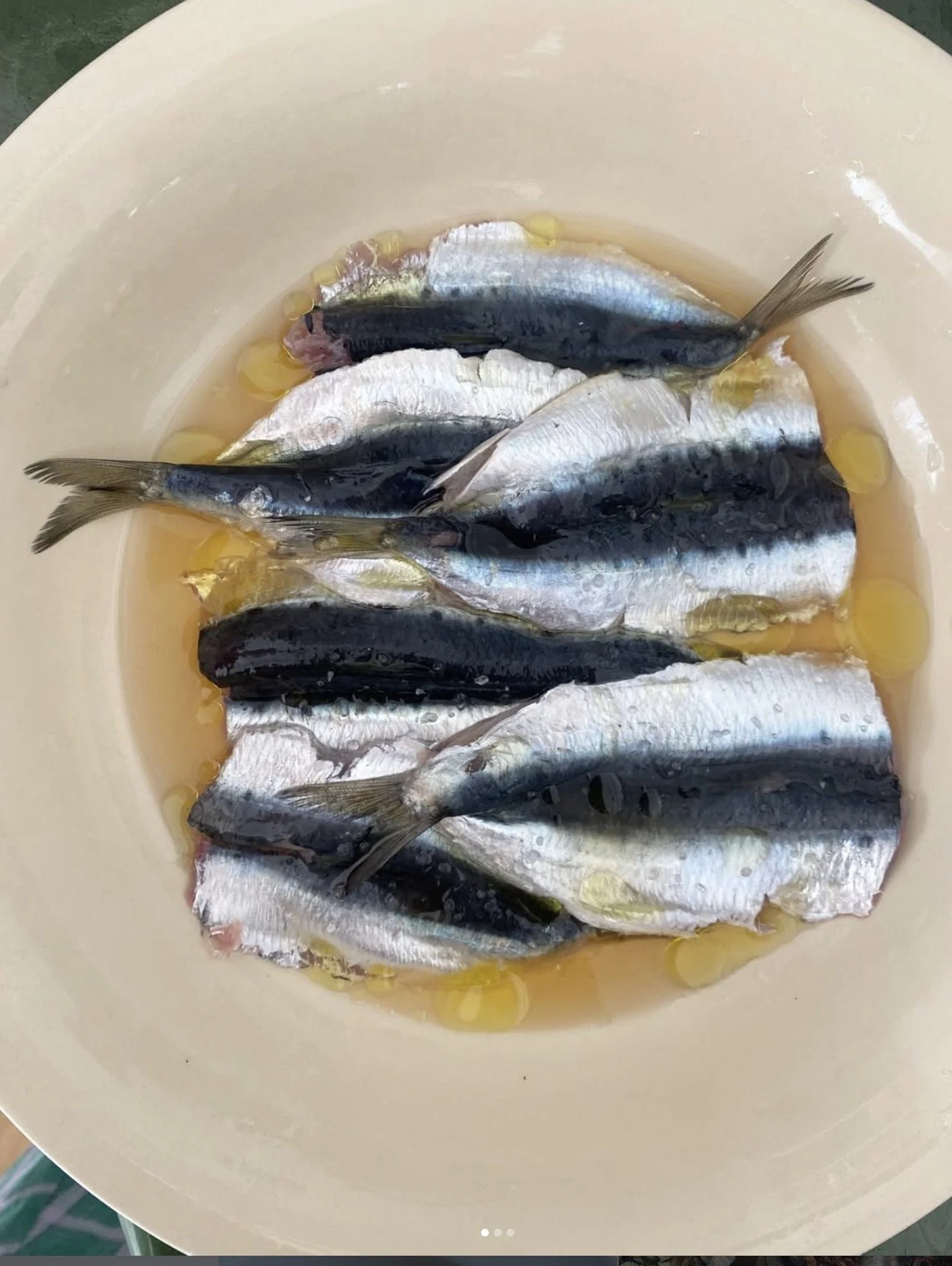 Poissons dans une bassine avec du jus de citron et de l'huile.